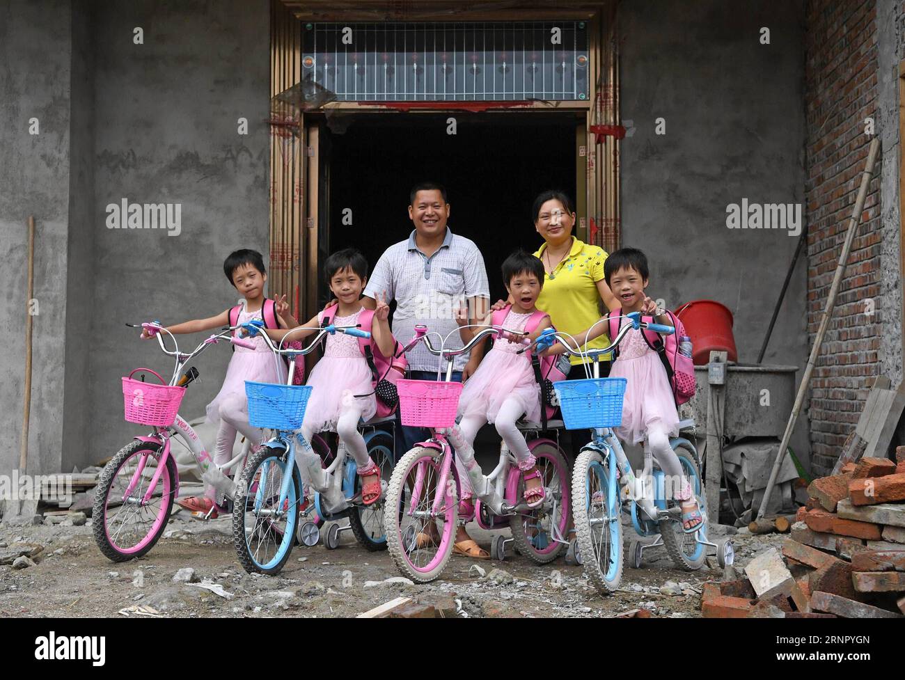 (170912) -- NANCHANG, 12 settembre 2017 -- Wu Nianyou, Deng Dinglan e i loro quadrupletti sono visti di fronte alla casa a tre piani in costruzione nel villaggio di Shangbao della contea di Chongyi nella città di Ganzhou, nella provincia di Jiangxi della Cina orientale, 7 settembre 2017. Padre Wu Nianyou e madre Deng Dinglan avevano le belle quadruple nel settembre del 2010. Da quel momento in poi, non hanno mai smesso di lottare contro la povertà e negli ultimi sette anni si è verificato un cambiamento fondamentale. Il marito è stato impegnato in un'attività per la raccolta di ratti di bambù e la sua attività è stata ampliata quest'anno con il numero di ratti in aumento Foto Stock