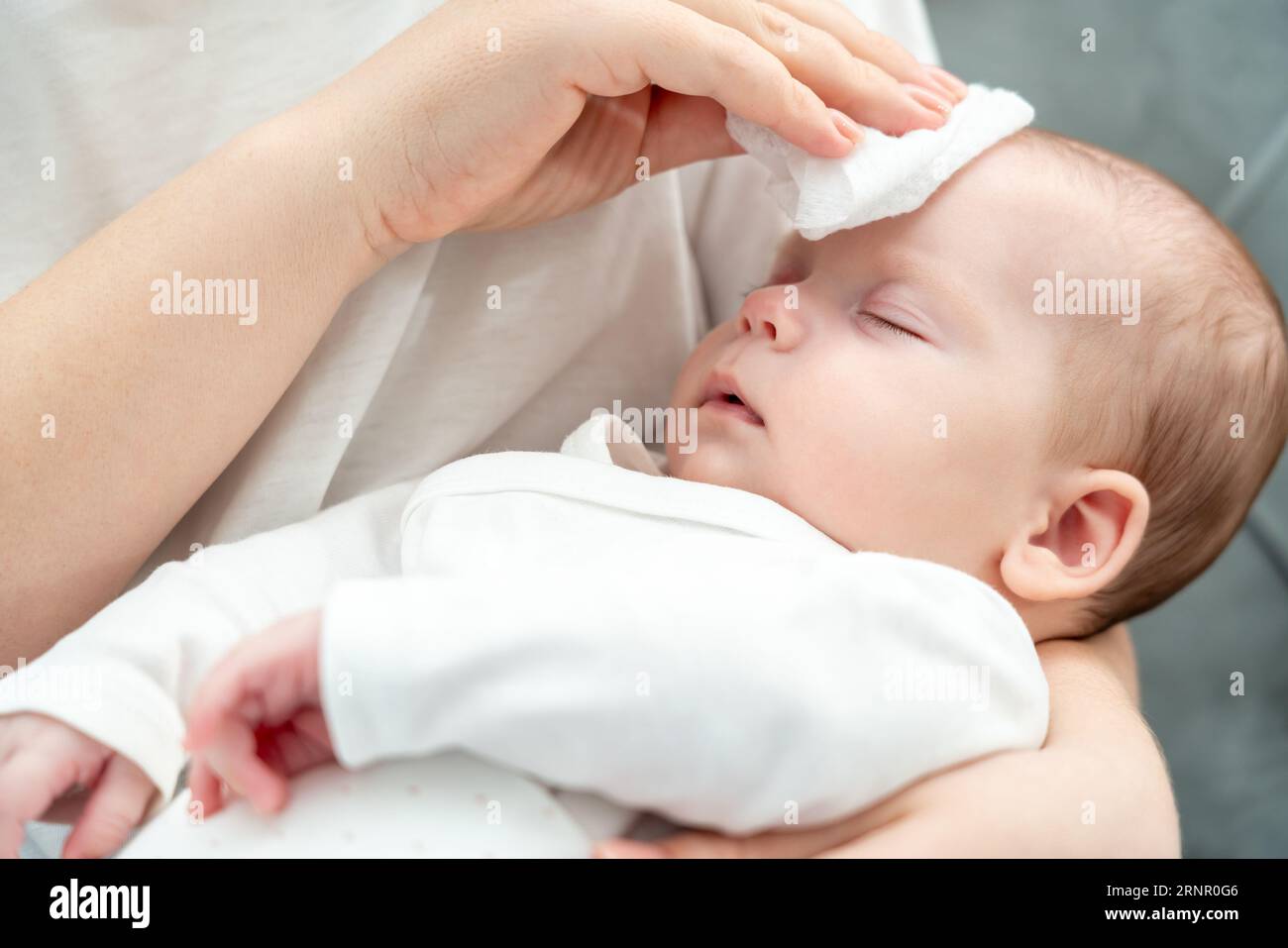 Tocco rinfrescante per un bambino febbrile, concetto di assistenza immediata della madre in caso di malattia Foto Stock