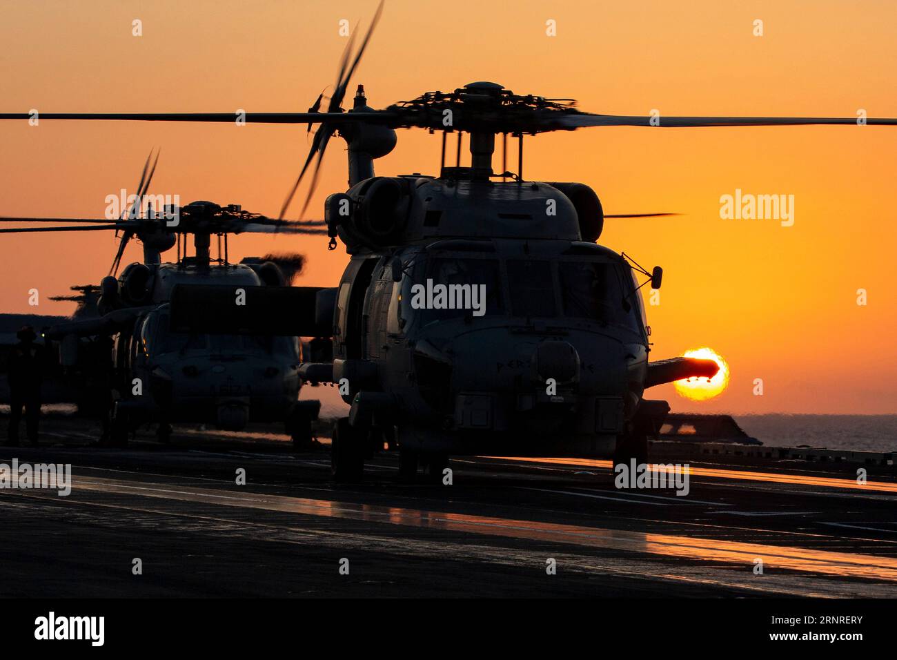 Mar Mediterraneo, acque internazionali. 30 agosto 2023. Un elicottero MH-60R Sea Hawk della Marina degli Stati Uniti, sagomato dal tramonto, si prepara al decollo dal ponte di volo a bordo della portaerei classe Nimitz USS Gerald R. Ford operante sul Mar Mediterraneo orientale, il 30 agosto 2023 al largo della costa greca. Credito: MC2 Nolan Pennington/U.S. Navy Photo/Alamy Live News Foto Stock