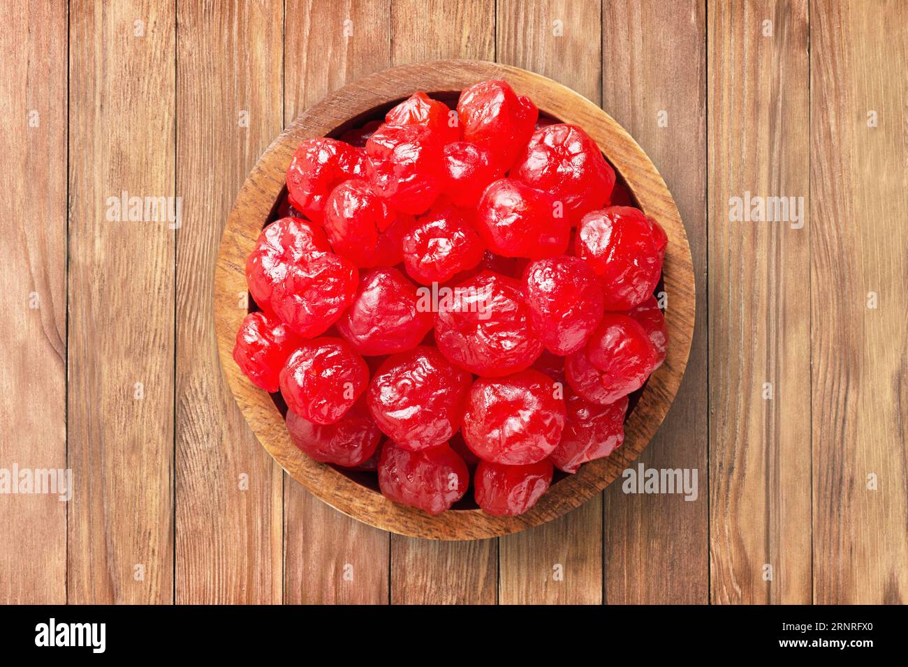 frutta candita, ciliegie secche con zucchero in una ciotola di legno sullo sfondo della tavola. cibo vegetale sano. Foto Stock