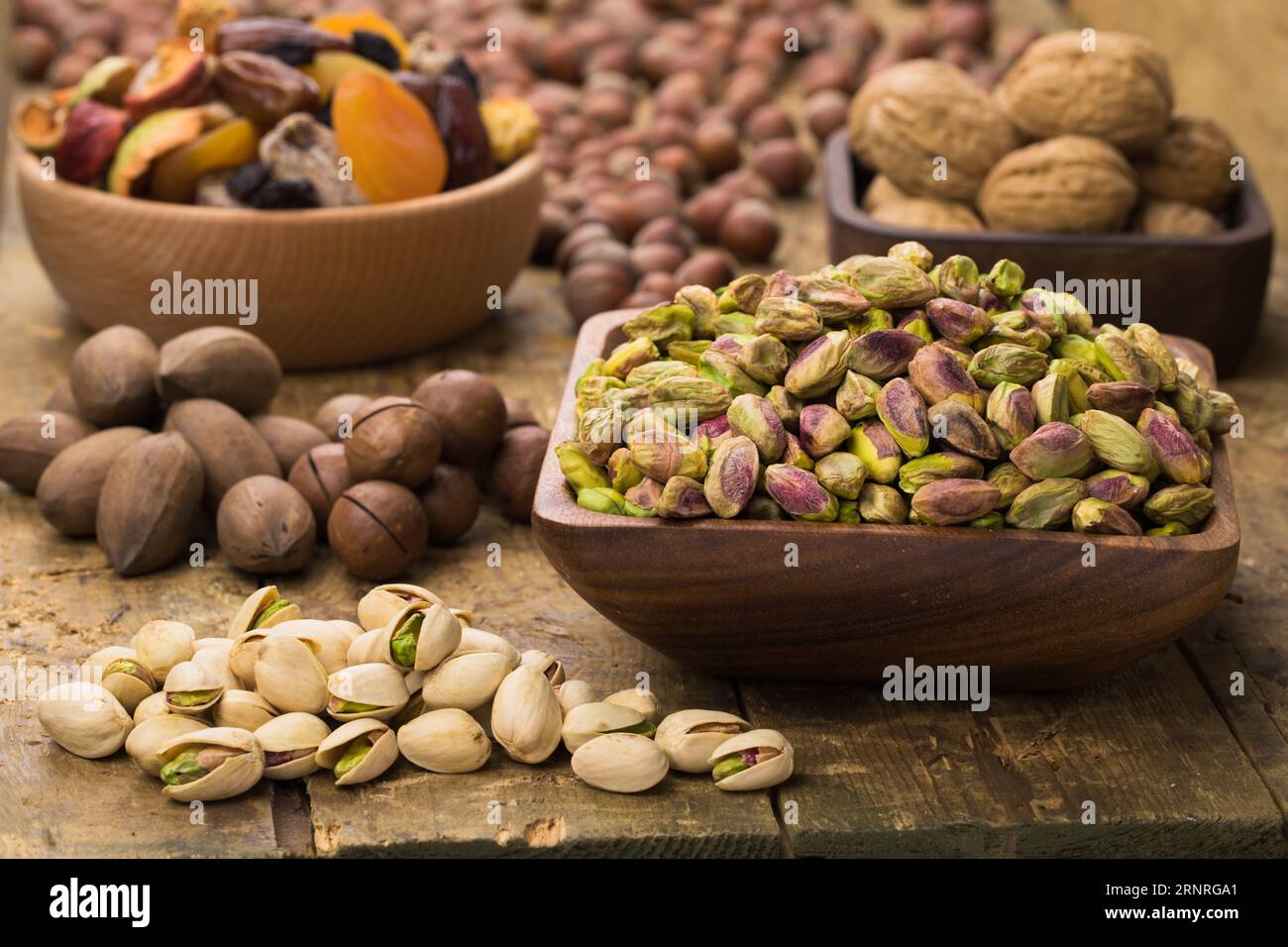 i pistacchi sbucciati in un recipiente su un tavolo di legno. Alimenti utili per vegetariani e vegani. Foto Stock