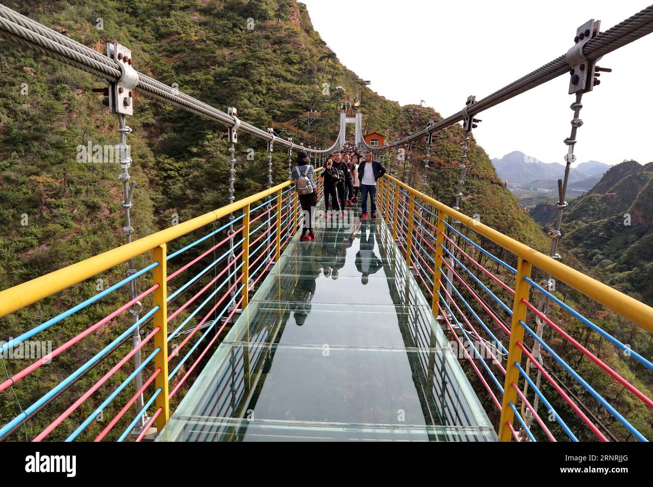 (171004) -- SHIJIAZHUANG, 4 ottobre 2017 -- i turisti camminano sul ponte con fondo di vetro durante la festa per la giornata Nazionale e il Festival di metà autunno in una valle nella città di Qian An, nella provincia di Hebei nella Cina settentrionale, 4 ottobre 2017. Il Festival di metà autunno di quest'anno cade il 4 ottobre. Il Festival di metà autunno, il 15° giorno dell'ottavo mese del calendario lunare cinese, è un'occasione per riunioni di famiglia e ben noto come il momento di mangiare le torte lunari. )(wsw) CHINA-MID-AUTUNNO FESTIVAL-CELEBRATION (CN) YangxShirao PUBLICATIONxNOTxINxCHN Foto Stock
