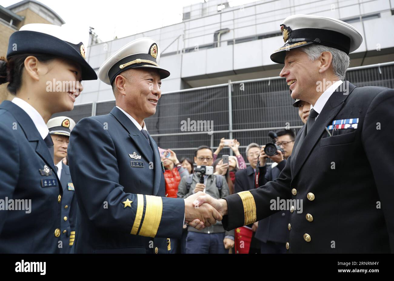 (171007) -- LONDRA, 7 ottobre 2017 -- il comandante della 26a flotta di scorta navale cinese Wang Zhongcai (2nd L, Front) stringe la mano a David Elford, comandante regionale navale britannico per l'Inghilterra orientale, durante una cerimonia di addio al West India Docks a Canary Wharf, Londra orientale, il 7 ottobre 2017. La 26a flotta di scorta navale della Cina è partita da qui sabato dopo una visita amichevole di cinque giorni in Gran Bretagna. La flotta, composta dalle fregate missilistiche guidate Huanggang e Yangzhou, e dalla nave di rifornimento completa Gaoyouhu, ha chiamato al Canary Wharf nella zona est di Londra martedì, la terza tappa del suo globale Foto Stock