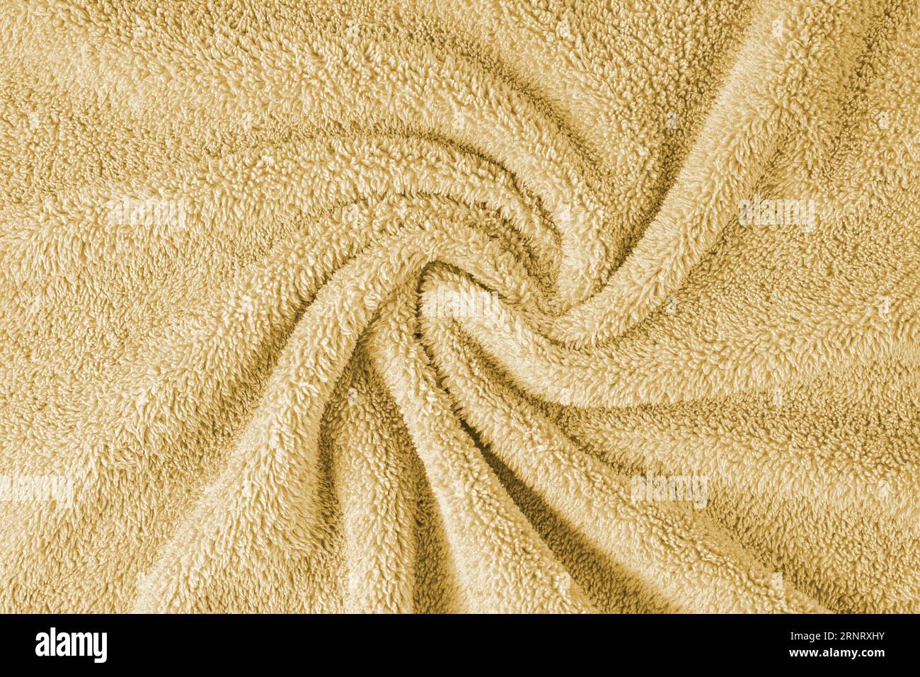 Panno di spugna, sfondo con trama di asciugamano giallo. Teli da bagno o da spiaggia morbidi stropicciati e stropicciati. Vista dall'alto, primo piano. Foto Stock