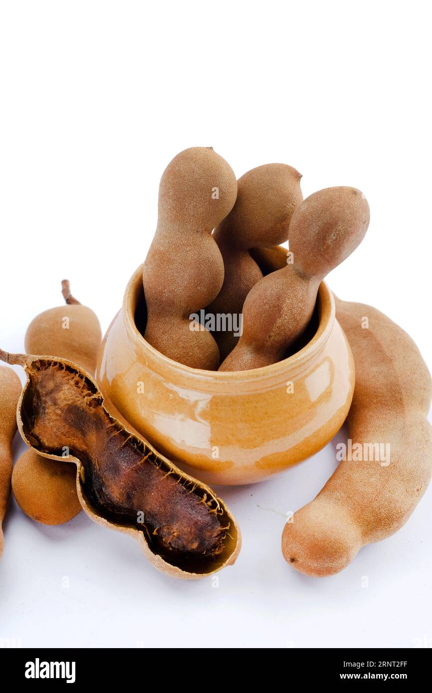 Tamarindi freschi e maturi, tamarindo con polpa marrone con foglia verde. Foto Stock