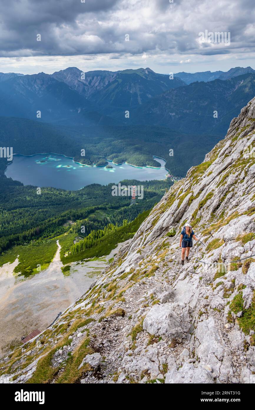 Via ferrata sopra il Riffelscharte, escursionista in montagna, vista del lago Eibsee e del Werdenfelser Land, dei Monti Wetterstein, Garmisch-Patenkirchen Foto Stock