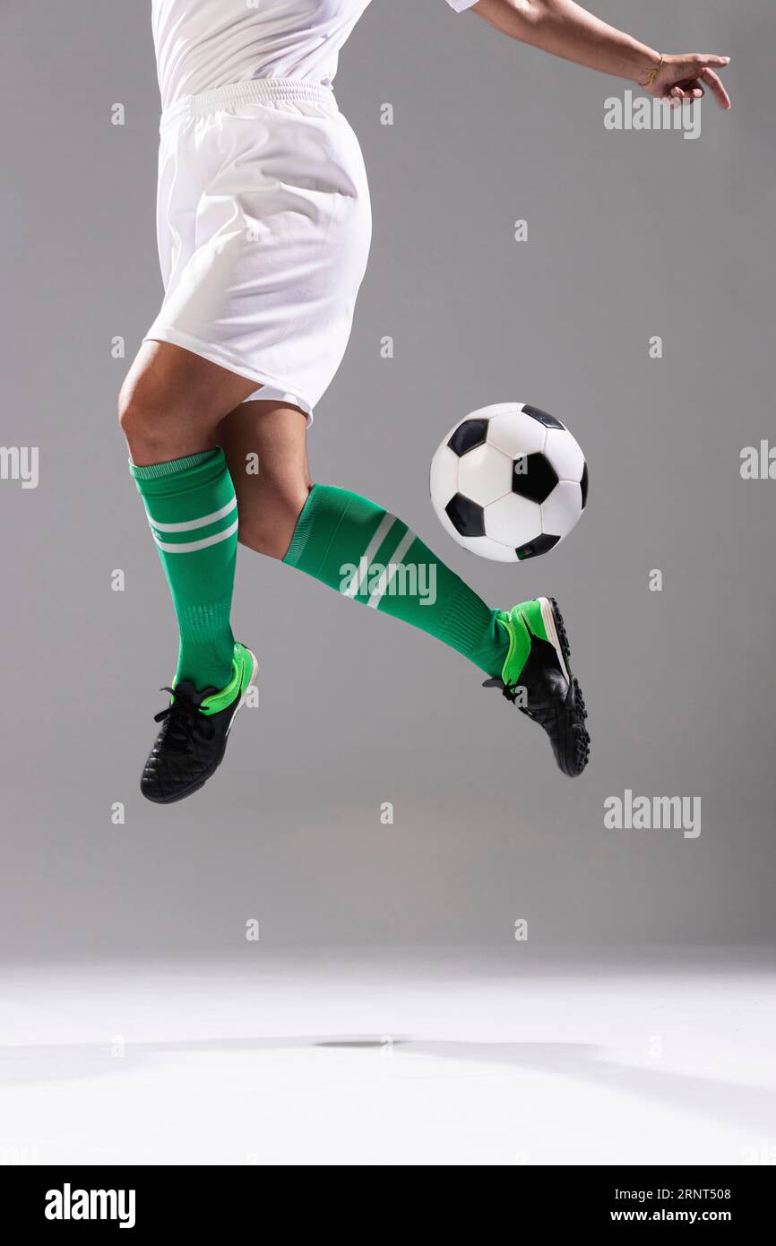 Donna adulta fare trucchi con palla di calcio Foto Stock