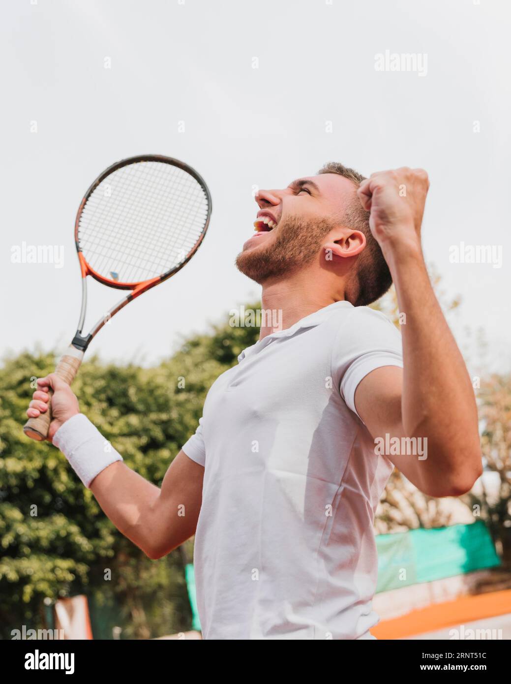 Un giovane ragazzo atletico che vince il gioco di tennis Foto Stock
