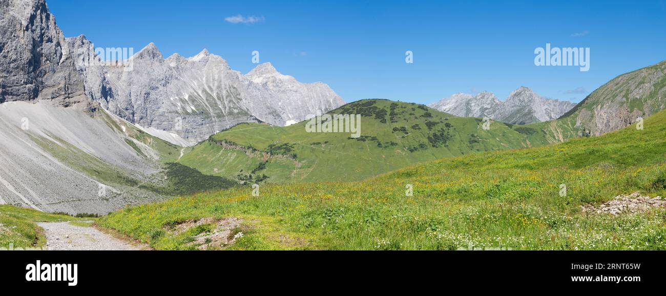 Le pareti settentrionali dei monti Karwendel guardano alle vette di Brikkarspitze e Kaltwasserspitze con lo chalet Falkenhutte. Foto Stock