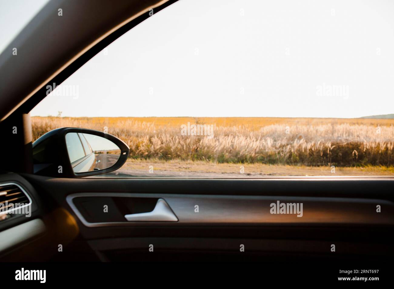 Vista sul campo soleggiato da un'auto elegante Foto Stock