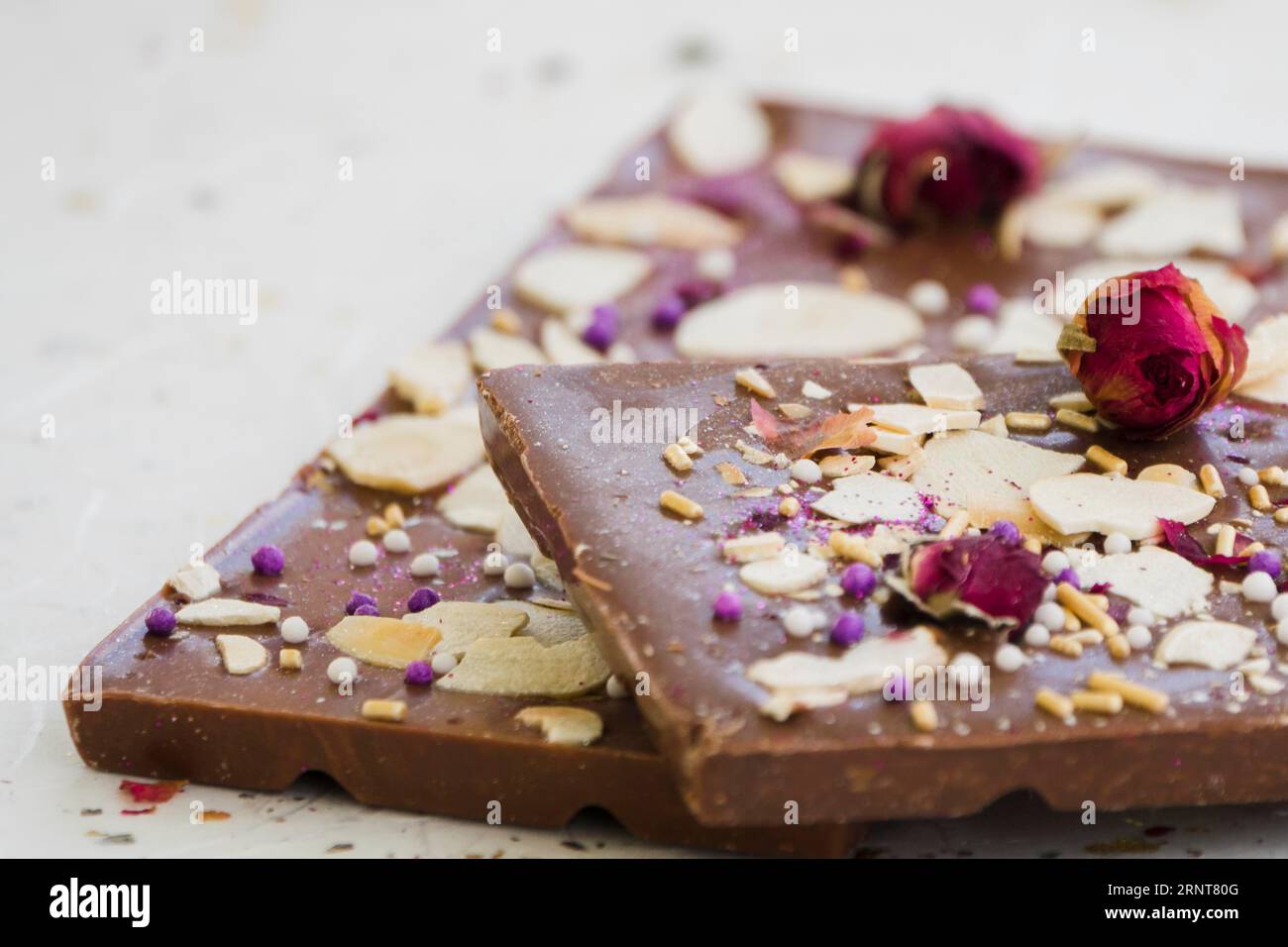 Bar al cioccolato con frutta secca sfondo bianco rosa Foto Stock