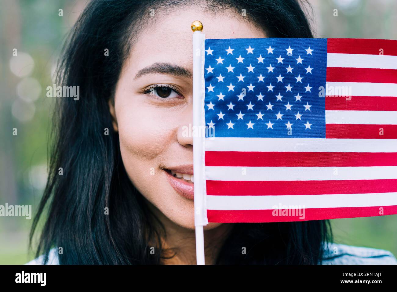 Donna patriottica che copre il volto con la bandiera degli stati uniti Foto Stock