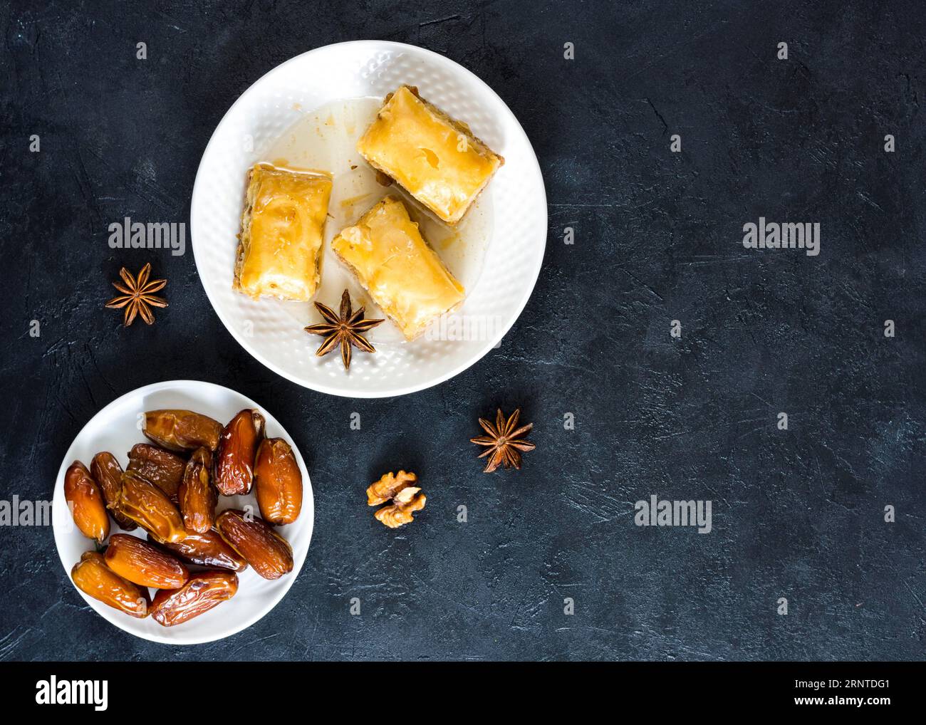 Dolci orientali con datteri, frutta e tavola nera Foto Stock