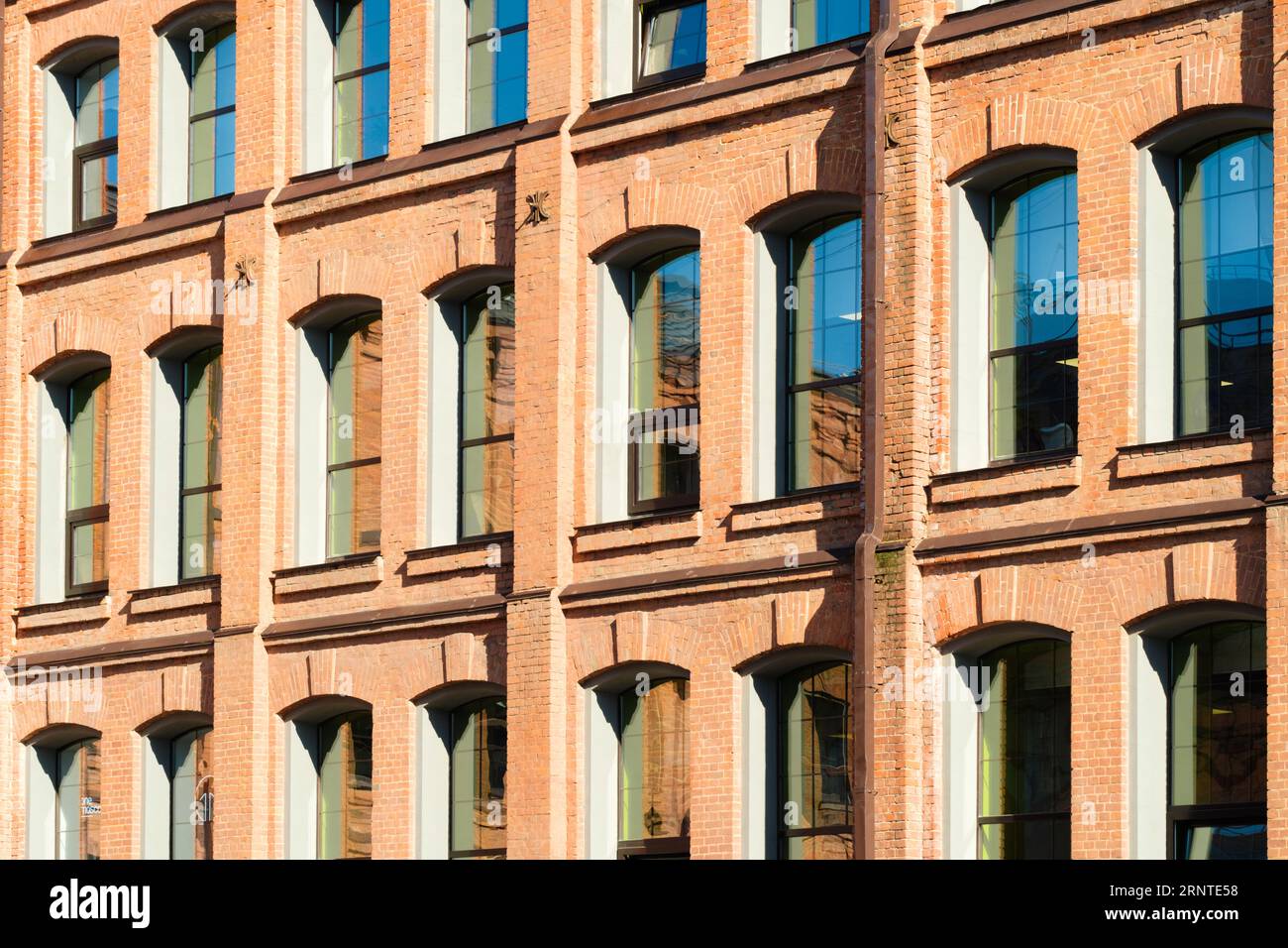 Vecchio edificio industriale in mattoni rossi con tubi di pioggia in metallo Foto Stock