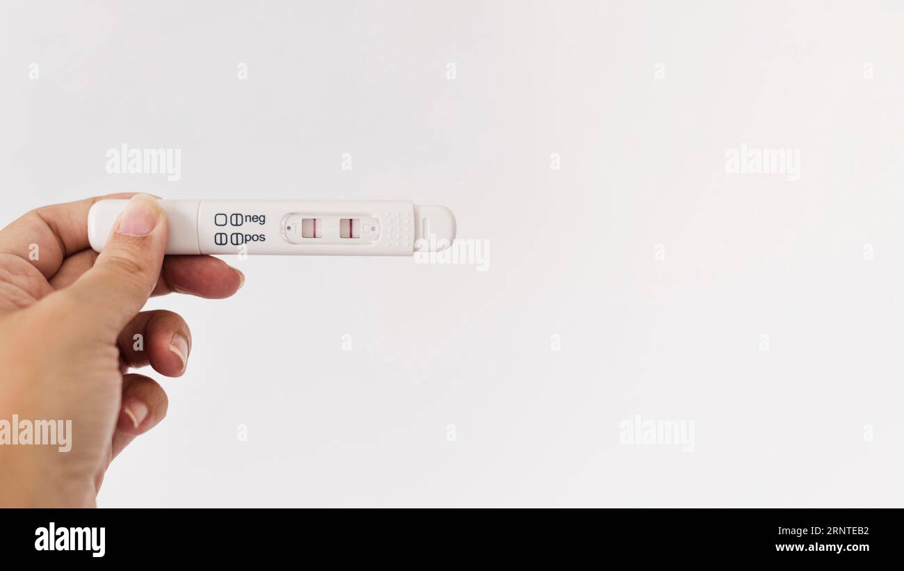 Test di gravidanza positivo per la mano Foto Stock