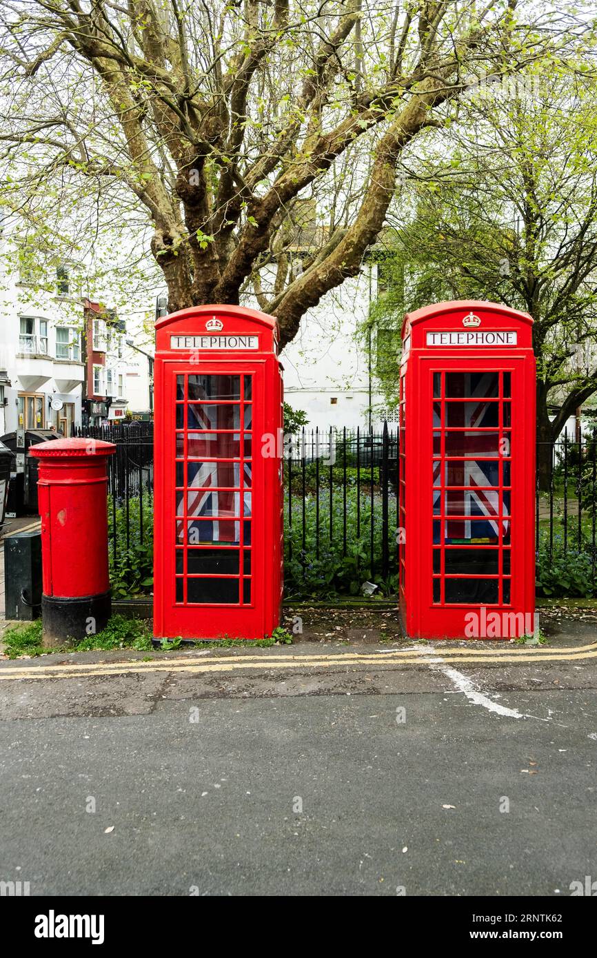 Due cabine telefoniche rosse inglesi con bandiere Union Jack, Brighton, East Sussex, Inghilterra, Regno Unito Foto Stock