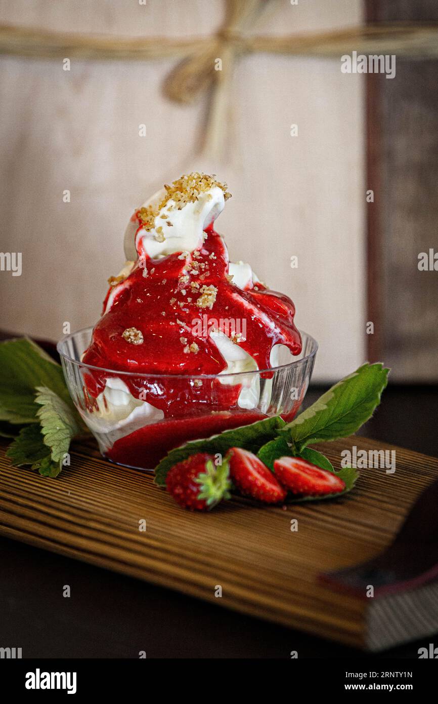 EIS mit einer Erdbersoße und streussel rundherum. Foto Stock