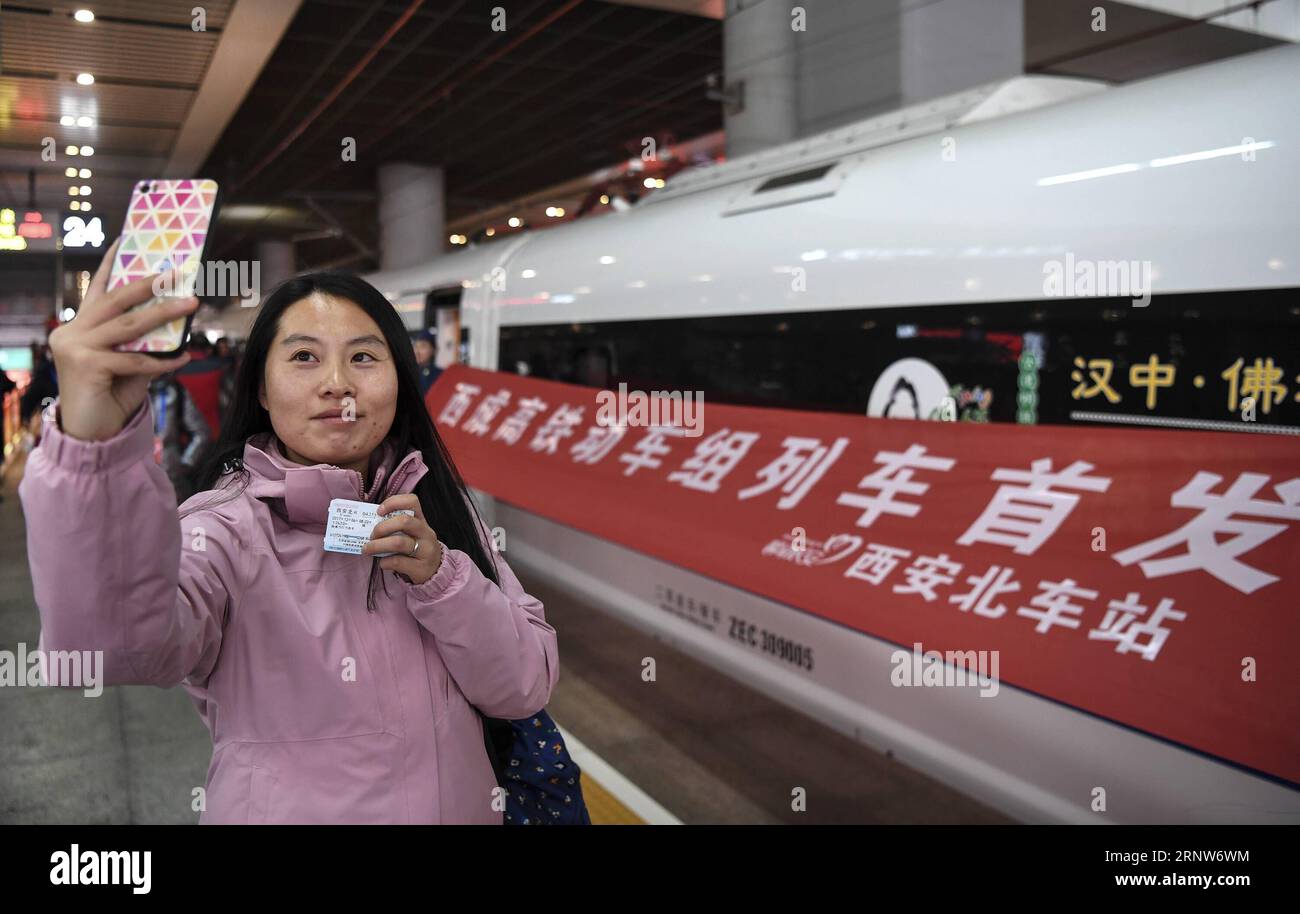 (171206) -- XI AN, 6 dicembre 2017 -- Un turista fa selfie accanto al primo treno ad alta velocità dalla Cina nord-occidentale Xi An alla Cina sud-occidentale Chengdu presso la stazione ferroviaria nord di Xi An, capitale della provincia di Shaanxi, 6 dicembre. 2017. La linea ferroviaria ad alta velocità che collega Xi An e Chengdu, capitale della provincia del Sichuan, è entrata in funzione mercoledì, riducendo il tempo di percorrenza tra le due città da circa 11 ore a sole 4. ) (LX) CHINA-XI AN-CHENGDU HIGH-SPEED RAILWAY-OPERATION (CN) TAOXMING PUBLICATIONXNOTXINXCHN Foto Stock