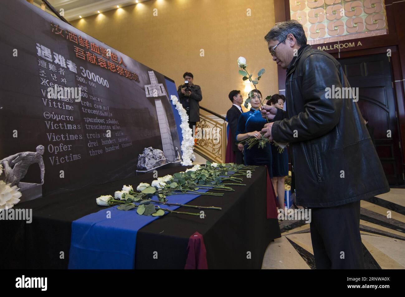 (171210) -- TORONTO, 10 dicembre 2017 -- Un visitatore presenta un fiore durante una cerimonia commemorativa per il 80° anniversario del massacro di Nanjing a Toronto, Canada, 9 dicembre 2017. Più di 1.000 persone hanno partecipato alla cerimonia di sabato. ) (Zxj) CERIMONIA DEL GIORNO COMMEMORATIVO DEL MASSACRO DI CANADA-TORONTO-NANJING ZouxZheng PUBLICATIONxNOTxINxCHN Foto Stock