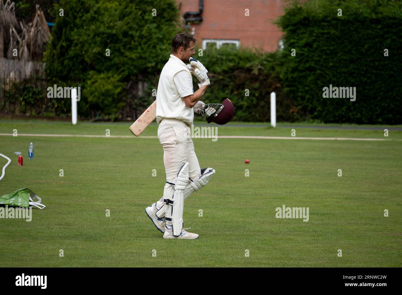 Un battitore di cricket del club che esce dal campo Foto Stock
