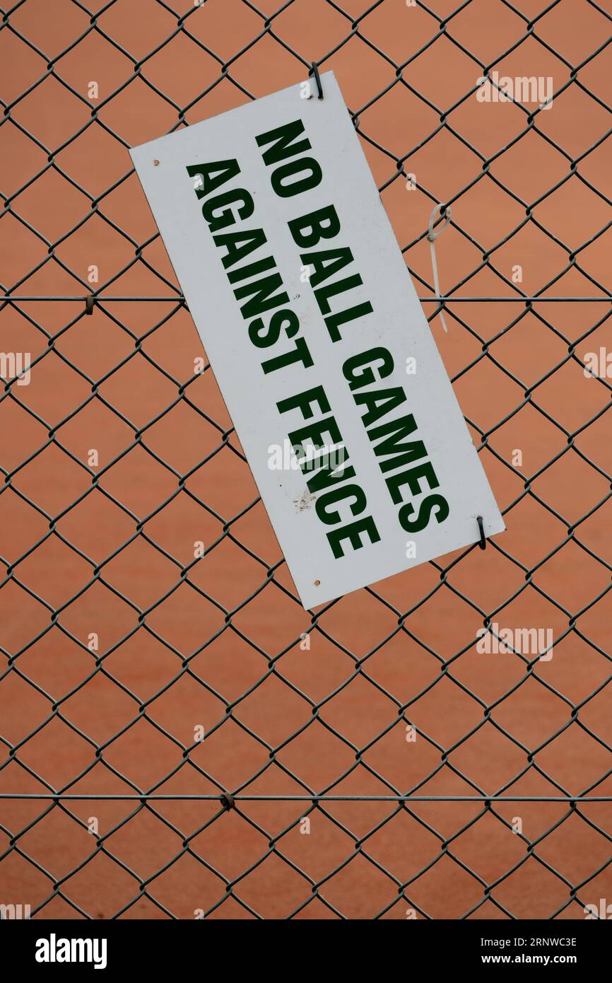 Cartello "no ball games against fence" sulla recinzione con maglie a catena Foto Stock