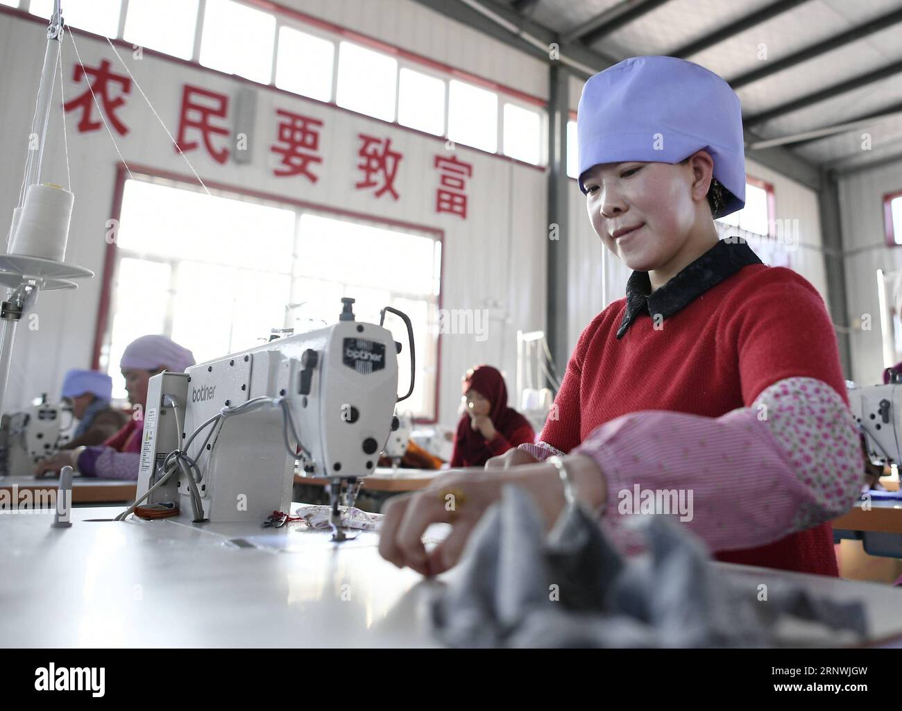 (171222) -- WUZHONG, 22 dicembre 2017 -- gli abitanti del villaggio imparano a fare vestiti durante una formazione nel villaggio di Hantianling della città di Hexi, città di Wuzhong, regione autonoma di Ningxia Hui, 21 dicembre 2017. La coppia lavorava per la cooperativa, con un reddito annuo superiore a 100.000 yuan (15.209 dollari USA). Hantianling, che significa montagna della siccità in cinese, si trova nella regione montuosa più remota di Ningxia. L'evaporazione annuale qui è superiore a 2.000 mm, mentre le precipitazioni annuali sono solo di circa 200 mm. La siccità è sempre stata la più grande minaccia per la popolazione locale. Non CE n'e' mai stato abbastanza Foto Stock