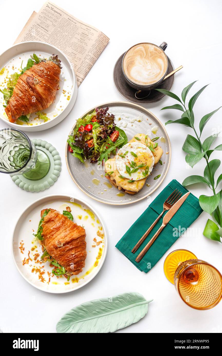 Set di piatti per la colazione: Croissant, toast, uova strapazzate, insalata, bruschette Foto Stock