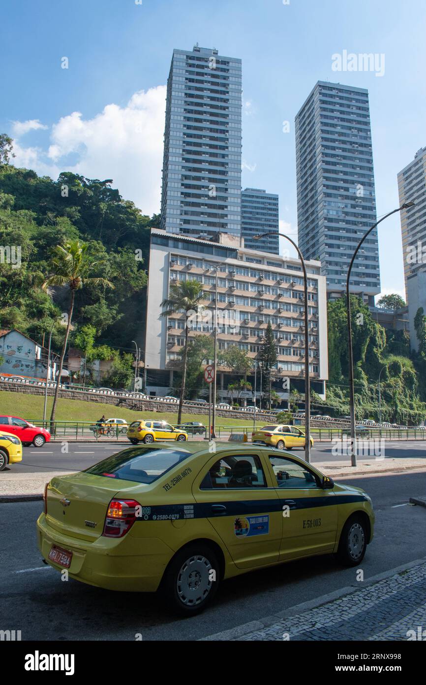 Rio de Janeiro, Brasile: Skyline della città con grattacieli, foresta pluviale e taxi lungo Avenida Lauro Sodré, strada trafficata nel quartiere di Botafogo Foto Stock