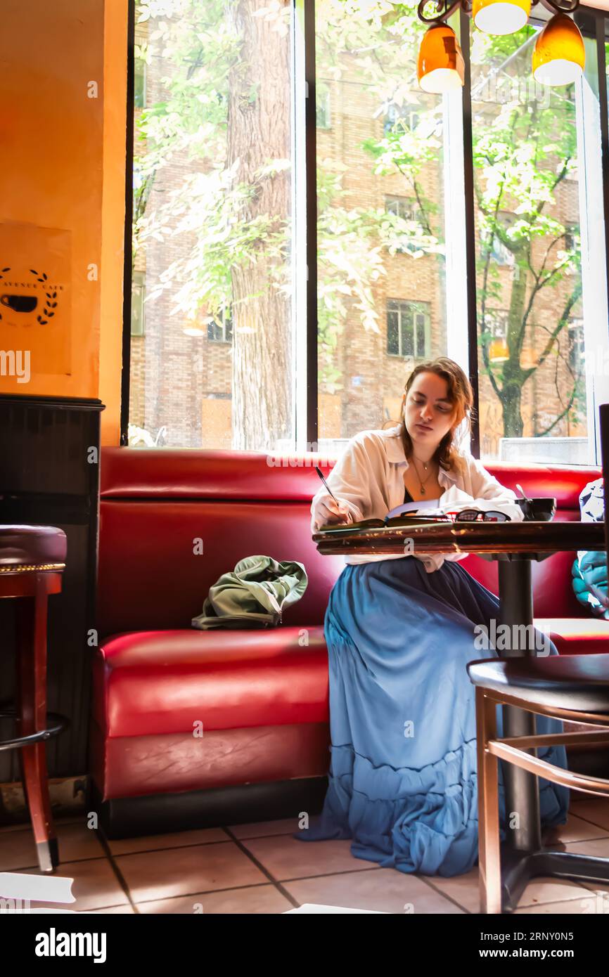 Studente che studia al Park Ave Cafe nel quartiere South Park Blocks di Portland, Oregon Foto Stock