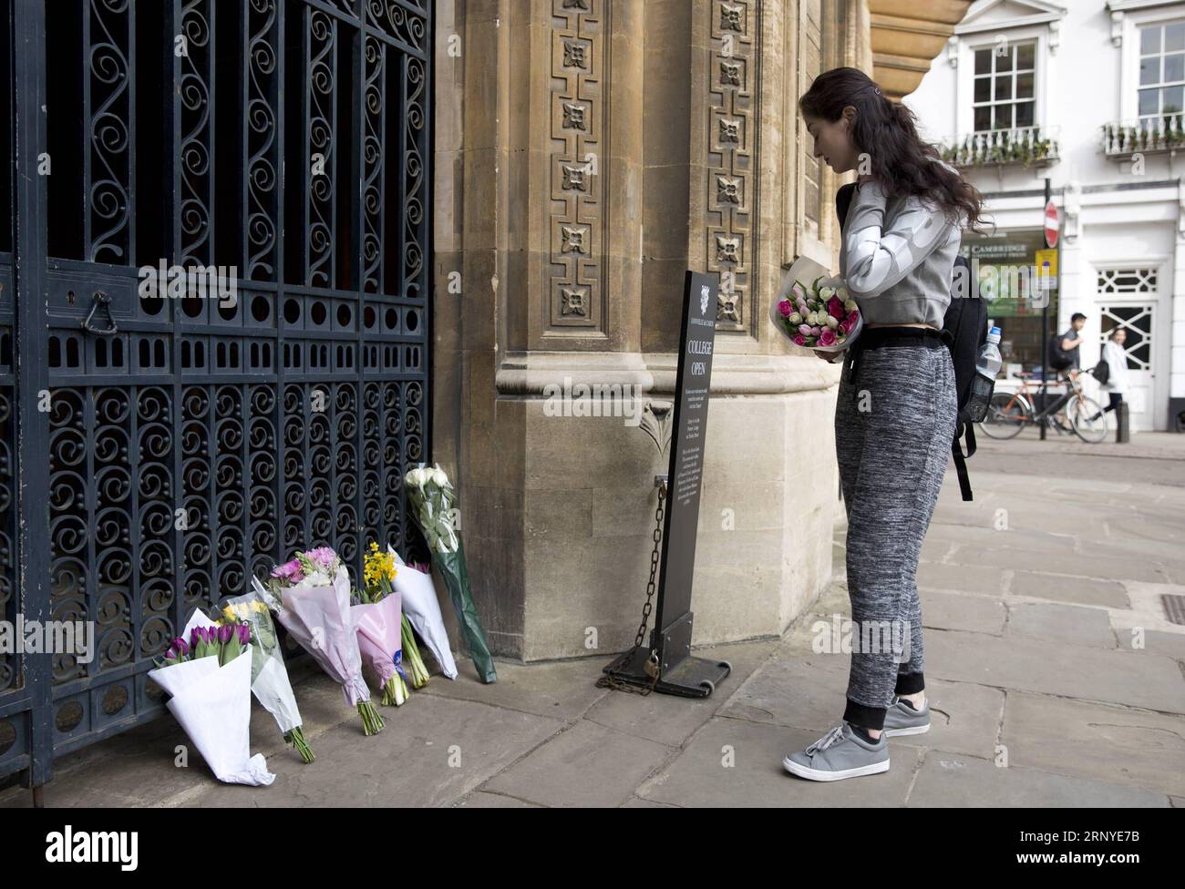 (180314) -- CAMBRIDGE (BRITAIN), 14 marzo 2018 -- Una donna poggia fiori al cancello del Gonville and Caius College dell'Università di Cambridge in seguito alla morte del famoso fisico Stephen Hawking a Cambridge, in Gran Bretagna, il 14 marzo 2018. La città universitaria di Cambridge stava rendendo omaggio a Stephen Hawking che morì all'età di 76 anni nella sua casa di Cambridge nelle prime ore di mercoledì. BRITAIN-CAMBRIDGE-STEPHEN HAWKING-OMAGGIO-PAGANTE ISABELXINFANTES PUBLICATIONXNOTXINXCHN Foto Stock