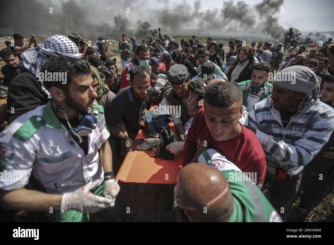 (180406) -- GAZA, 6 aprile 2018 -- i manifestanti palestinesi trasportano un uomo ferito durante gli scontri con le truppe israeliane sul confine tra Gaza e Israele, a est della città di Gaza, il 6 aprile 2018. Otto palestinesi sono stati uccisi e altri 1.070 feriti venerdì durante una giornata di sanguinosi scontri tra centinaia di manifestanti palestinesi e soldati israeliani al confine tra Israele e la Striscia di Gaza, hanno detto i medici). MIDEAST-GAZA-CLASH WissamxNassar PUBLICATIONxNOTxINxCHN Foto Stock