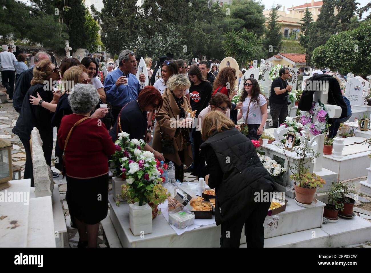 (180415) -- ATENE, 15 aprile 2018 -- i greci si riuniscono in un cimitero per onorare i loro cari defunti ad Atene, in Grecia, il 15 aprile 2018. I cimiteri di tutto il mondo sono legati al dolore della perdita e alle lacrime di dolore. Per migliaia di greci pontiani, un gruppo eticamente vissuto per secoli sulle rive del Mar Nero e ora disperso in tutto il mondo, una volta all'anno, i luoghi di sepoltura dei loro cari defunti vengono trasformati in un luogo di gioia. La prima domenica dopo la Pasqua cristiana greco-ortodossa le famiglie si riuniscono nei cimiteri, mettono la tavola sulle tombe di marmo, mangiano prelibatezze, bevono vino, Foto Stock