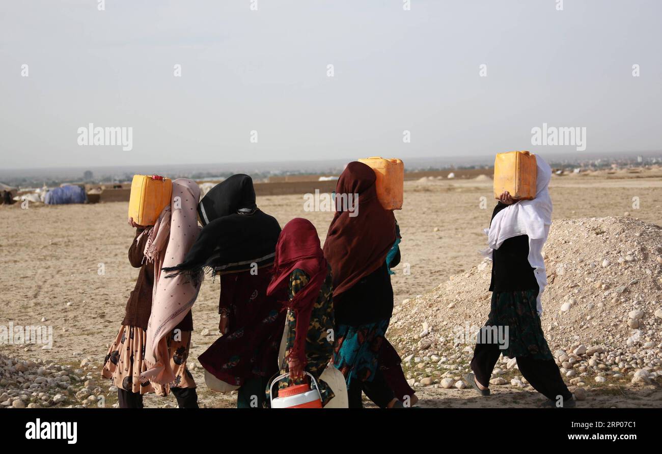 (180424) -- MAZAR-i-SHARIF, 24 aprile 2018 -- la foto scattata il 20 aprile 2018 mostra che gli sfollati trasportano barili per ricevere acqua da una pompa dell'acqua locale in un campo profughi nella parte meridionale di Mazar-i-Sharif, capitale della provincia settentrionale di Balkh, Afghanistan. La scarsità d'acqua emanata dalla mancanza di precipitazioni alla fine del 2017 e all'inizio di quest'anno ha colpito la vita di 500.000 bambini in Afghanistan, l'UNICEF ha avvertito martedì. ) (wtc) AFGHANISTAN-BALKH-SICCITÀ RahmatxAlizadah PUBLICATIONxNOTxINxCHN Foto Stock