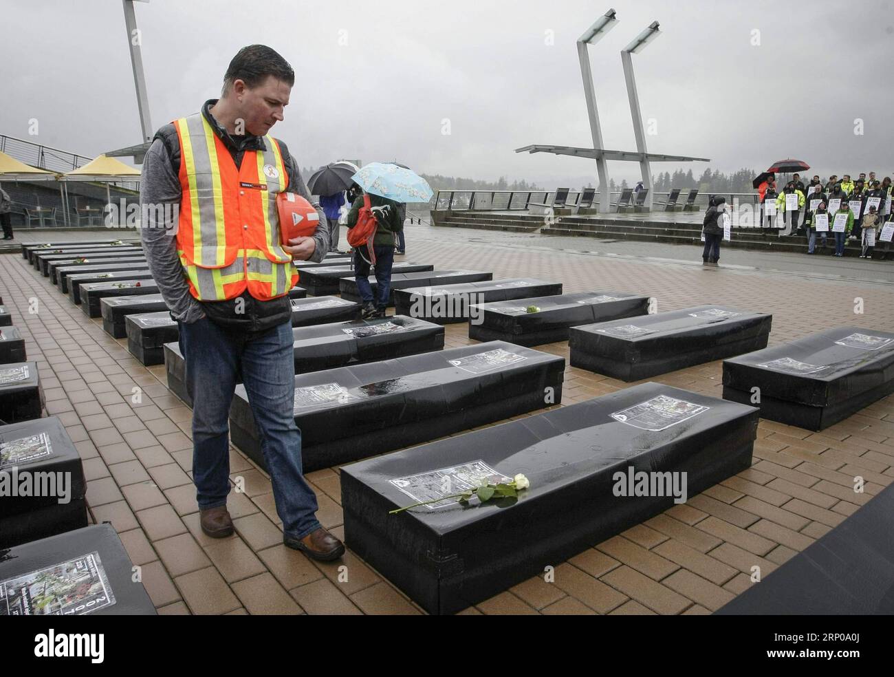 (180429) -- VANCOUVER, 29 aprile 2018 -- Un lavoratore guarda le bare finte esposte alla giornata nazionale del lutto a Vancouver, Canada, 28 aprile 2018. Centinaia di persone hanno partecipato alla giornata nazionale del lutto del Canada, che si celebra il 28 aprile per commemorare le vittime o i feriti a causa di pericoli e incidenti legati al luogo di lavoro, e sensibilizzare l'opinione pubblica sulla sicurezza sul luogo di lavoro. )(yk) CANADA-VANCOUVER-GIORNATA NAZIONALE DI LUTTO LiangxSen PUBLICATIONxNOTxINxCHN Foto Stock