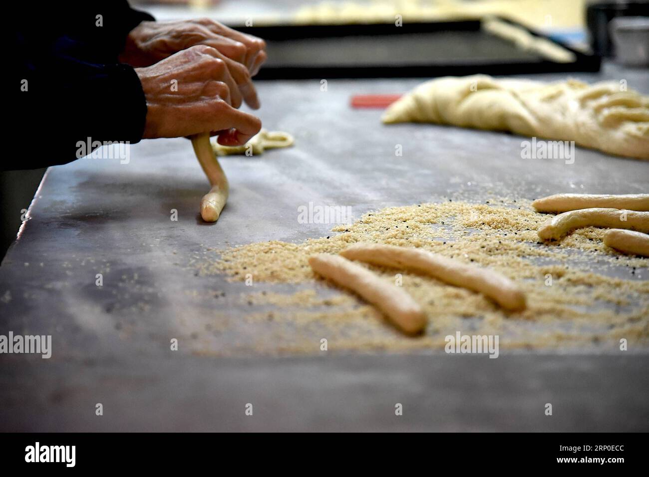 (180510) -- ALEPPO, 10 maggio 2018 -- Un fornaio prepara grissini di sesamo in un'antica panetteria nella vecchia città di Aleppo, nel nord della Siria, il 6 maggio 2018. Questa panetteria produce vari tipi di biscotti e bagel, il più famoso dei quali è il grissetto con semi di sesamo, noto come Kaak al-Sakhaneh in arabo. Erano il cibo preferito dai viaggiatori e dai mercanti sull'antica via della seta. (Zcc) SYRIA-ALEPPO-BAKERY HummamxSheikhxAli PUBLICATIONxNOTxINxCHN Foto Stock