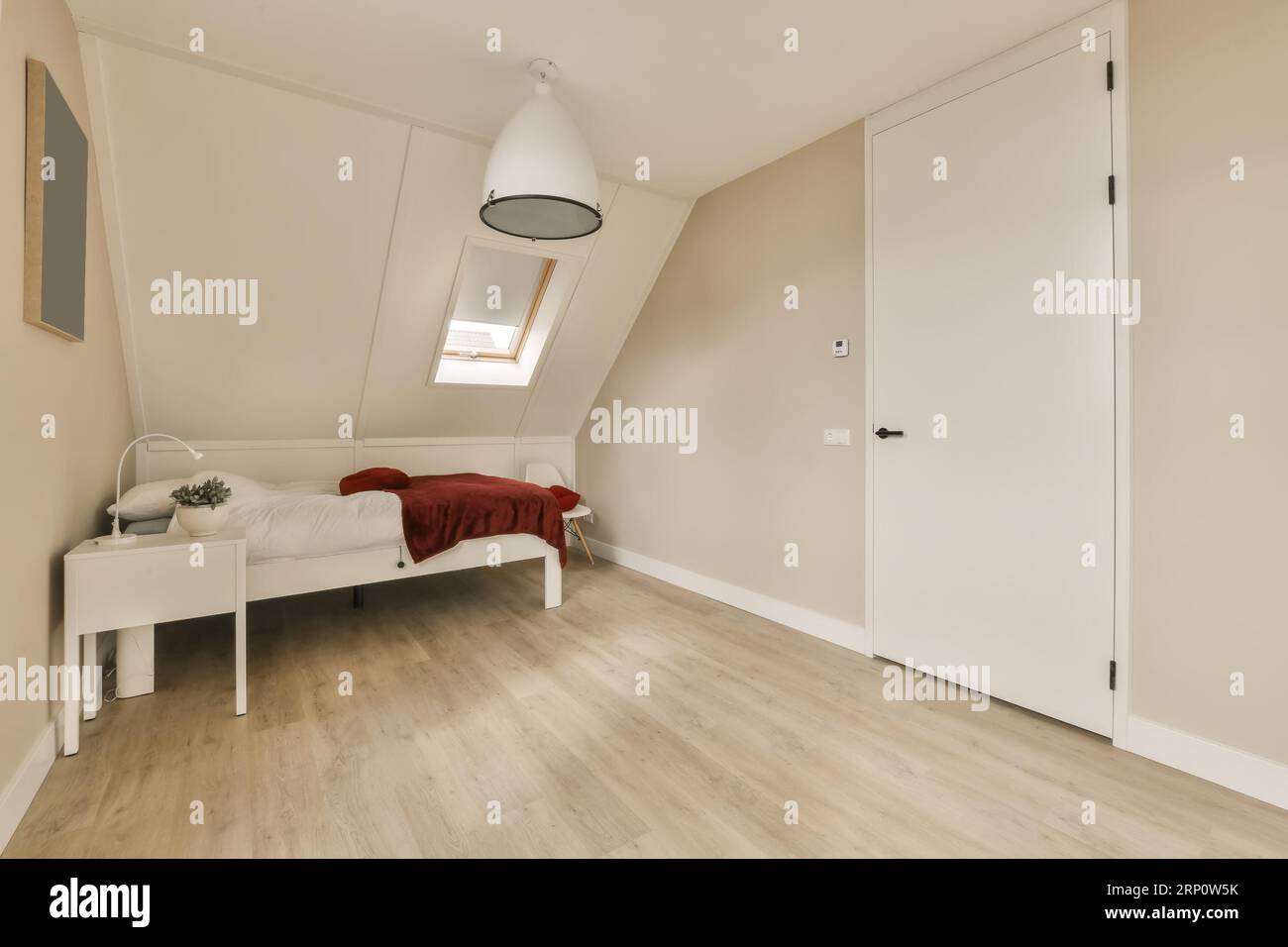 una camera da letto con pareti bianche e pavimento in legno in una casa di  stile mansardato, che mostra la pittura di colore chiaro sulle pareti Foto  stock - Alamy