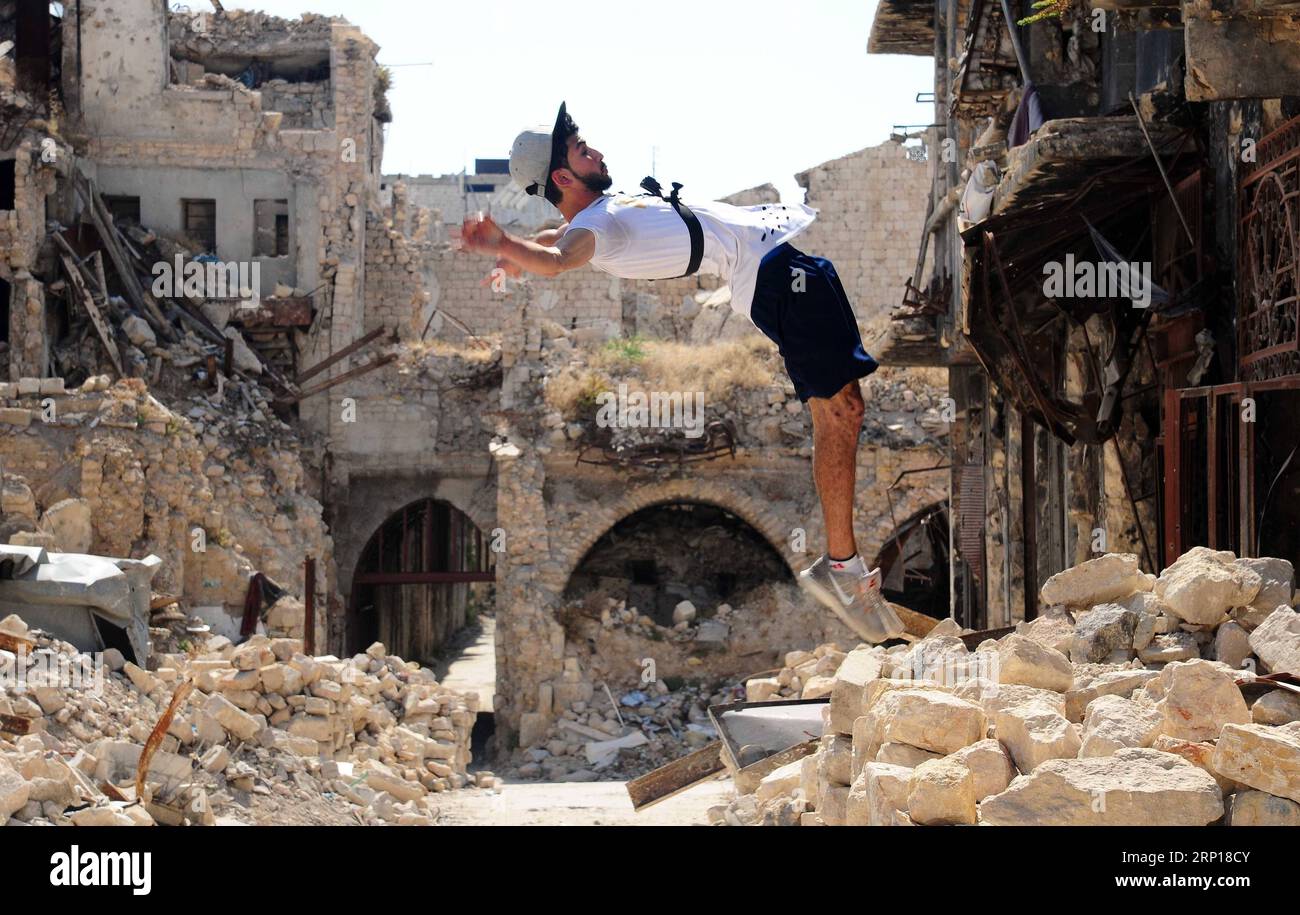(180617) -- ALEPPO, 17 giugno 2018 -- Un giovane giocatore di parkour siriano esegue un backflip alto nella parte in gran parte danneggiata della città di Aleppo, nel nord della Siria, l'8 giugno 2018. Con le loro acrobazie mozzafiato e salti acrobatici, un gruppo di giovani siriani sta riportando vita nelle parti distrutte della città di Aleppo con la loro elettrizzante esibizione in Parkour. PER ANDARE CON la caratteristica: I giovani siriani rianimano la vita nelle vecchie rovine di Aleppo con un'elettrizzante prestazione di Parkour. ) (hy) SYRIA-ALEPPO-PARKOUR-FEATURE AmmarxSafarjalani PUBLICATIONxNOTxINxCHN Foto Stock