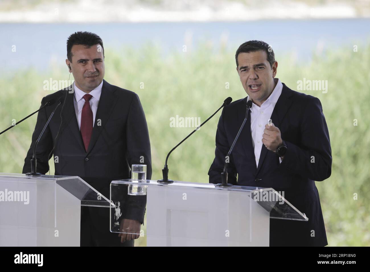 (180617) -- PRESPES, 17 giugno 2018 -- il primo ministro greco Alexis Tsipras (R) e il primo ministro dell'ex Repubblica jugoslava di Macedonia (FYROM) Zoran Zaev (L) partecipano a una cerimonia di firma sulla fila bilaterale dei nomi, a Psarades, nella regione dei laghi Prespes in Grecia, il 17 giugno 2018. La Grecia e l'ex Repubblica jugoslava di Macedonia (FYROM) hanno siglato un accordo storico domenica, ponendo fine alla controversia iniziata nel 1991 sull'uso del nome Macedonia. Secondo l'accordo preliminare firmato dai ministri degli Esteri dei due paesi, essi accettarono di rinominare la nazione balcanica in re Foto Stock