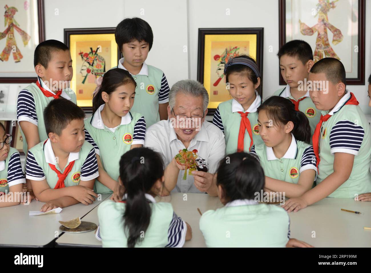 (180619) -- TANGSHAN, 19 giugno 2018 -- gli studenti imparano le abilità di intaglio dei burattini ombra sotto la guida dell'artista folk Liu Jiawen (C) presso la scuola primaria sperimentale No. 3 nella contea di Laoting, nella provincia di Hebei, nella Cina settentrionale, 19 giugno 2018. Per proteggere ed ereditare la cultura tradizionale, in molte scuole primarie locali vengono offerte lezioni sul burattino ombra di Laoting. )(wsw) CINA-HEBEI-SHADOW MARIONETTA (CN) MuxYu PUBLICATIONxNOTxINxCHN Foto Stock