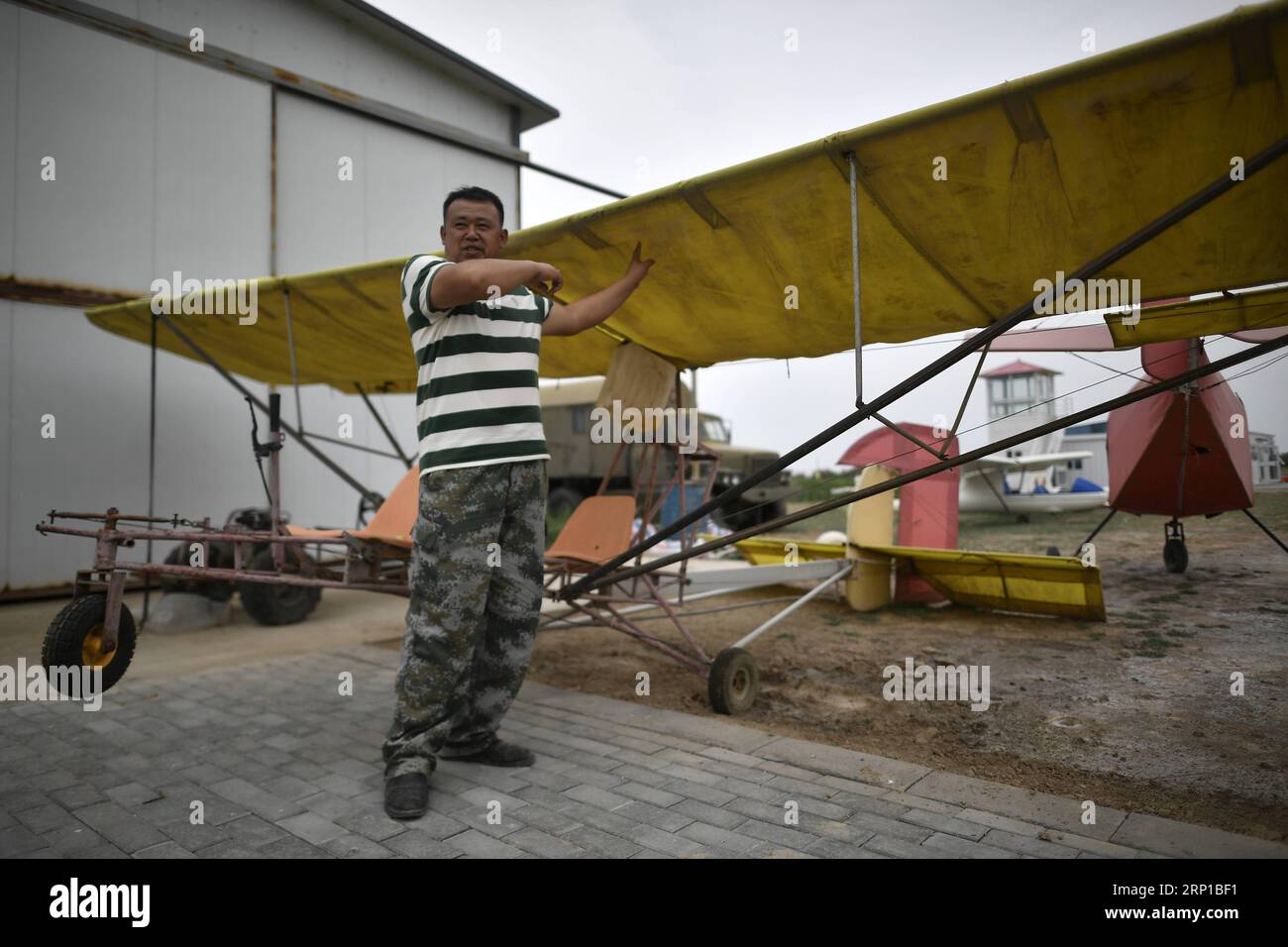 (180623) -- YINCHUAN, 23 giugno 2018 -- Liu Yibing si trova di fronte a un aereo nel suo club aerodinamico nella contea di Helan della città di Yinchuan, nella regione autonoma di Ningxia Hui della Cina nord-occidentale, 20 giugno 2018. Liu Yibing, 46 anni, è nata in una famiglia contadina. All'età di 17 anni, fu ispirato a costruire un aereo super leggero da solo dopo aver letto una rivista di aviazione. Trascorse tutto il suo tempo libero nella ricerca e nell'autoapprendimento per assemblare gli aerei dopo aver finito il lavoro sul campo. Ottenne con successo una licenza attraverso il dipartimento nazionale dell'aviazione e fece il suo primo volo nel 1996. Liu ha partecipato a decine di voli Foto Stock