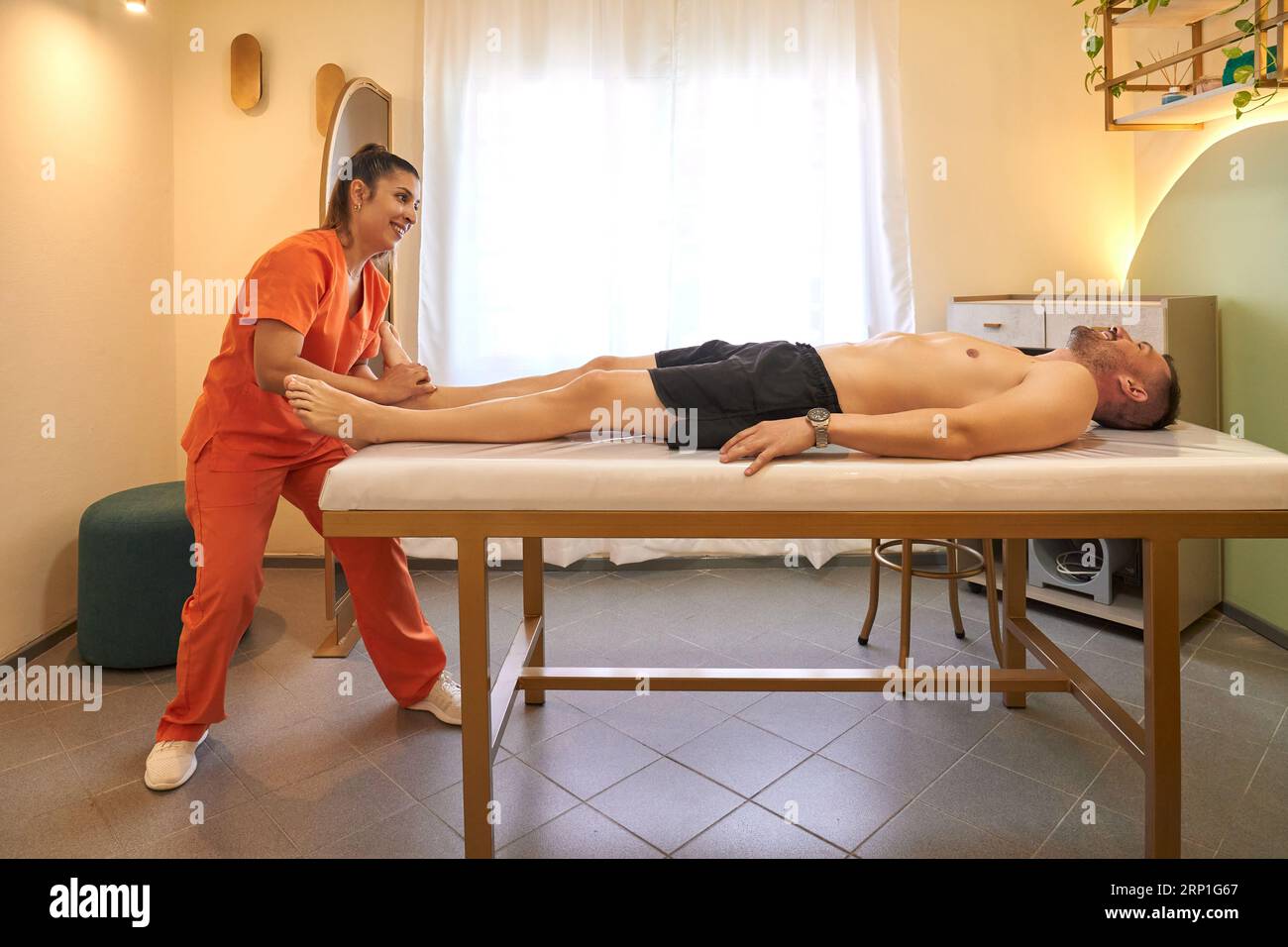 Massaggiatrice femminile che fa un massaggio ad un uomo Foto Stock