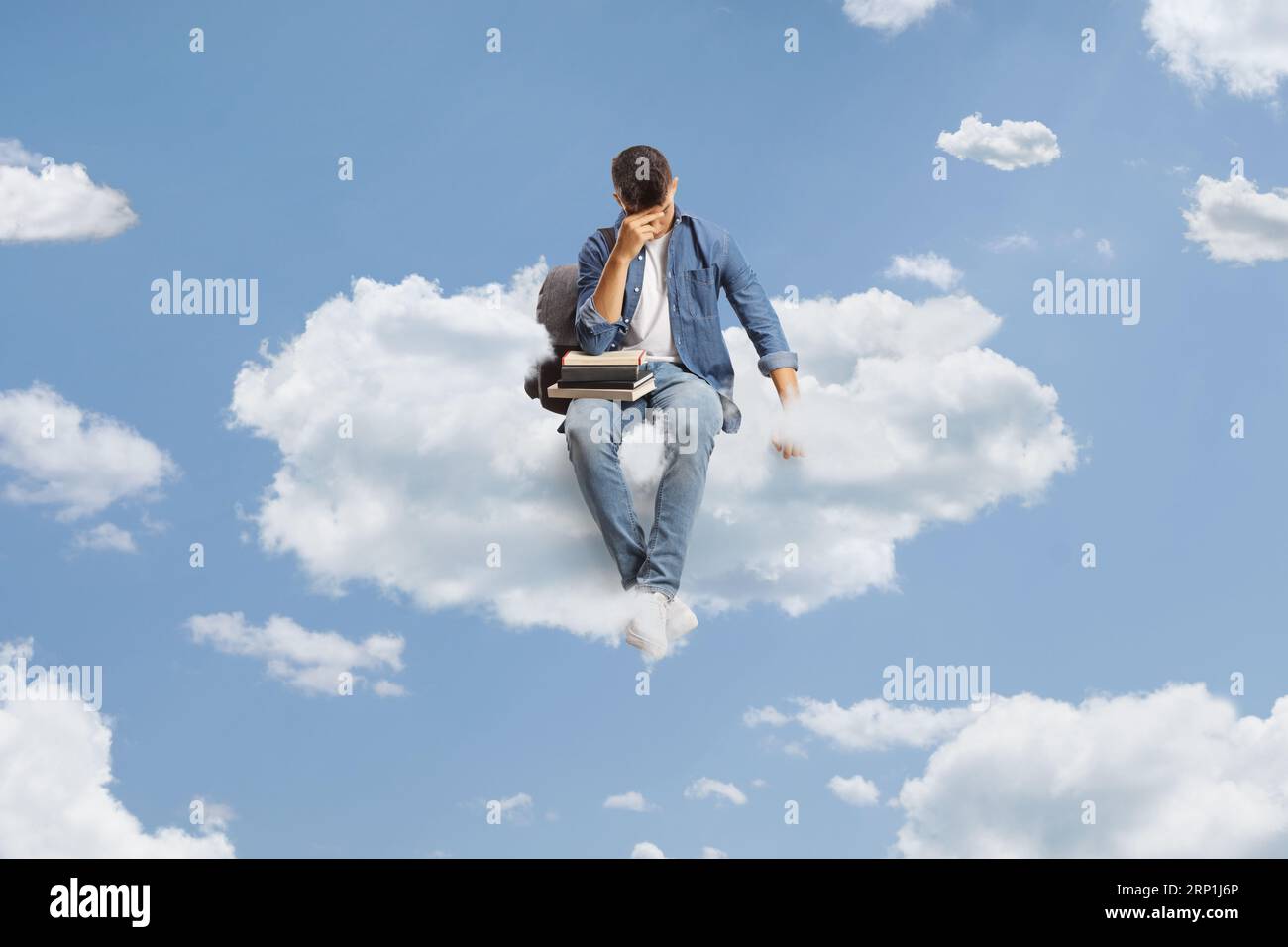 Triste studente maschio seduto su una nuvola in cielo Foto Stock