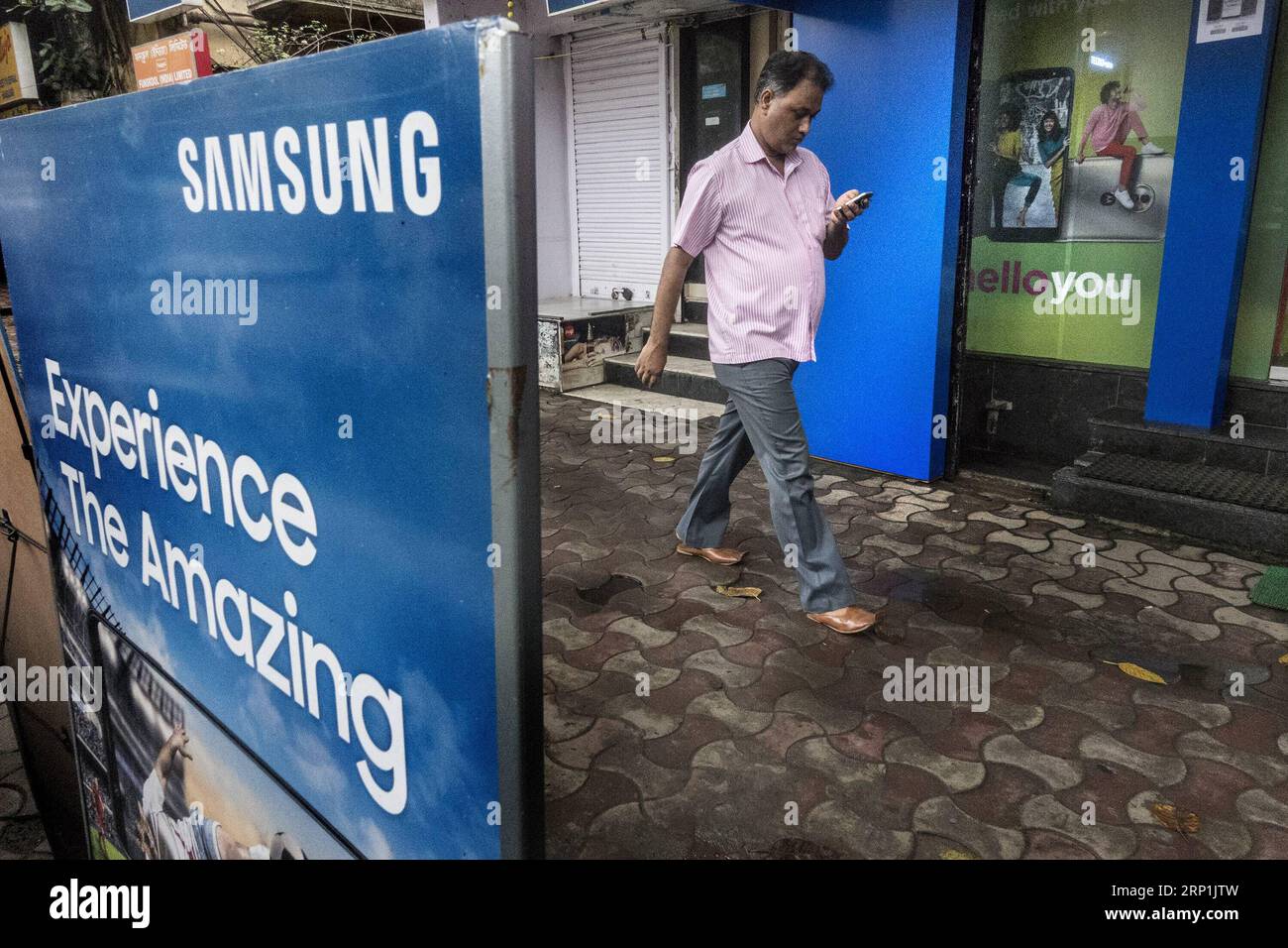 (180710) -- CALCUTTA, 10 luglio 2018 -- Un pendolare cammina di fronte a un negozio di cellulari Samsung a Calcutta, in India, il 10 luglio 2018. Il primo ministro indiano Narendra modi e il presidente della Corea del Sud Moon Jae-in lunedì hanno inaugurato una fabbrica di mobili vicino a Delhi a Noida, hanno detto i funzionari. I rapporti dicono che la nuova fabbrica che si estende su 35 acri di terreno produrrebbe 10 milioni di telefoni al mese, il 70% dei quali sarà venduto sul mercato interno. )(lrz) INDIA-SAMSUNG-INVESTMENTS TumpaxMondal PUBLICATIONxNOTxINxCHN Foto Stock