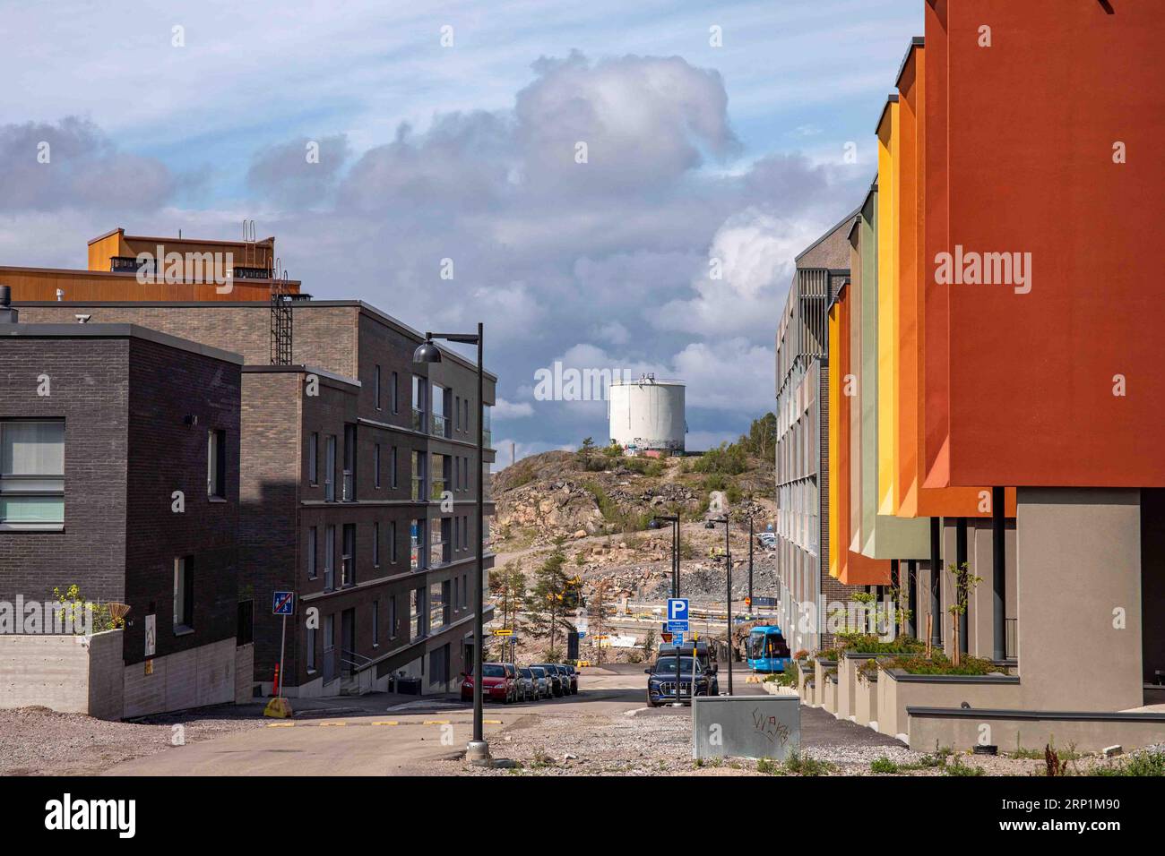 Vista sulla strada di Pojamankatu con un vecchio serbatoio di petrolio sullo sfondo nel quartiere Kruunuvuorenranta di Helsinki, Finlandia Foto Stock