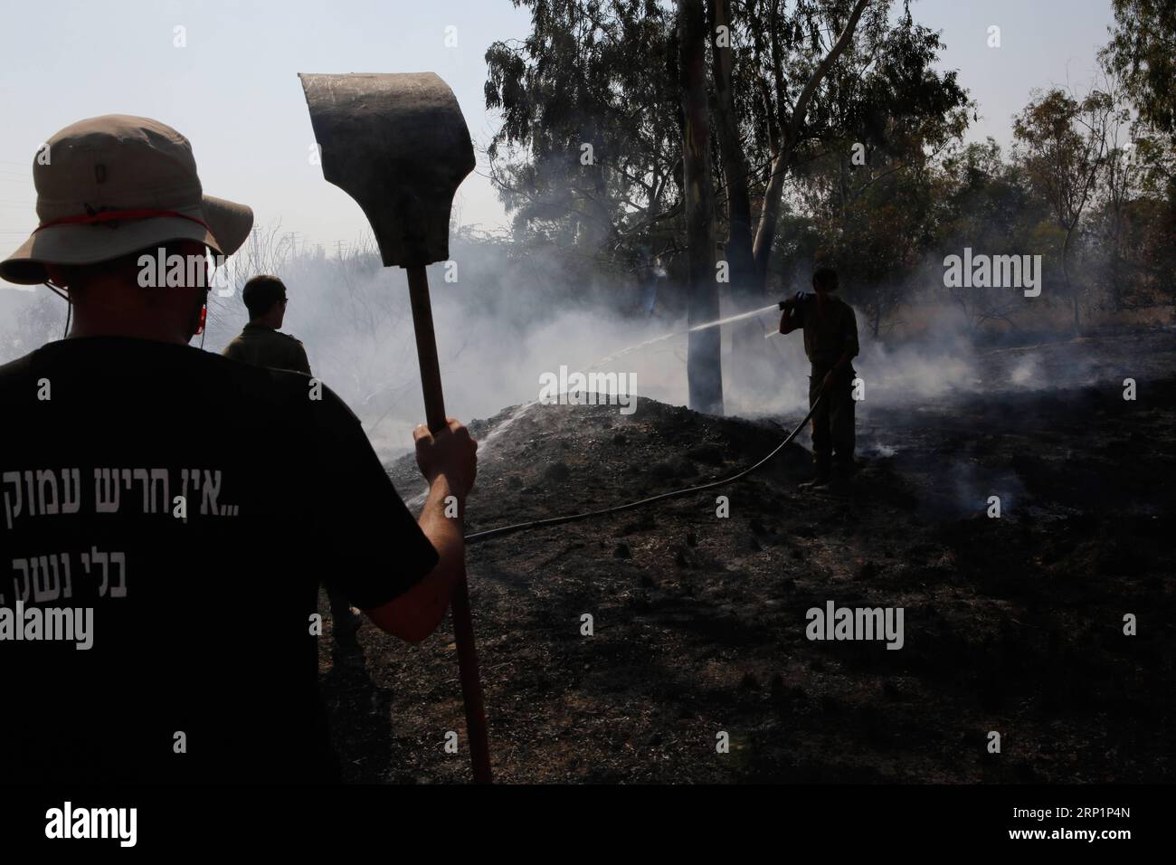 (180718) - NAHAL OZ, 18 luglio 2018 - i vigili del fuoco israeliani tentano di spegnere un incendio in un campo forestale vicino al Kibbutz di Nahal Oz, vicino alla barriera tra Israele e la Striscia di Gaza, il 17 luglio 2018. L'incendio è stato causato da materiale infiammabile attaccato a un pallone lanciato da manifestanti palestinesi dall'interno della Striscia di Gaza. (Qxy) MIDEAST-NAHAL OZ-FIRE GilxCohenxMagen PUBLICATIONxNOTxINxCHN Foto Stock