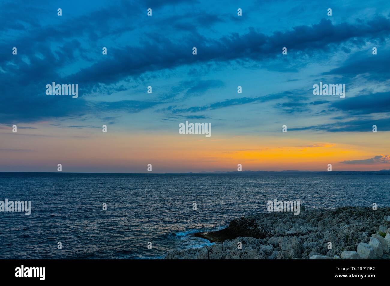 Tramonto sul Mar Mediterraneo, sulla Baia di Nizza e sulle montagne delle Alpi, sulla costa rocciosa al largo della città turistica di Saint-Jean-Cap-Ferrat a capo Ferrat, sulla Costa Azzurra Foto Stock
