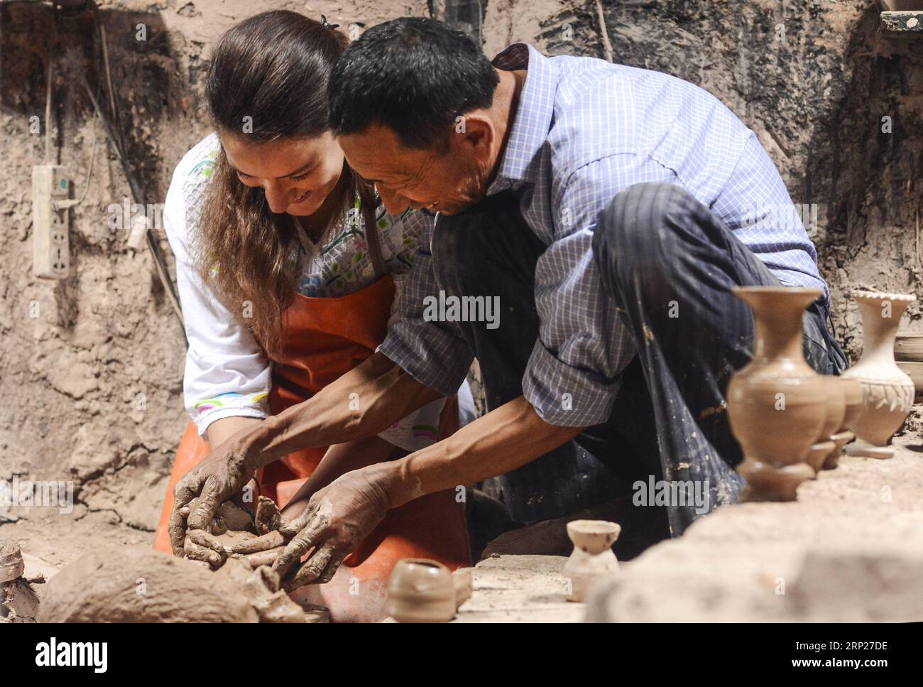 (180823) -- PECHINO, 23 agosto 2018 -- Tursun Zunun (R), un rinomato vasaio, aiuta un turista italiano (L) a modellare l'argilla nella sua casa a Kashgar, regione autonoma dello Xinjiang Uygur della Cina nord-occidentale, 18 maggio 2018. ) Titoli Xinhua: I cuori dello Xinjiang, le menti si aprono a Silk Road MaxKai PUBLICATIONxNOTxINxCHN Foto Stock