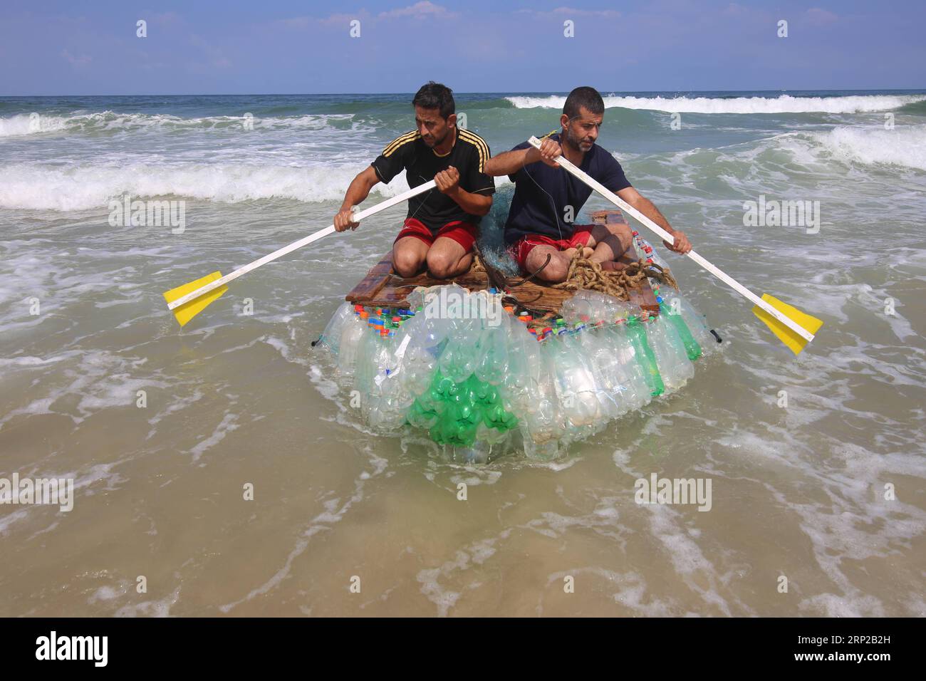 (180828) -- GAZA, 28 agosto 2018 -- il pescatore palestinese Mouath Abu Zeid (L) e il suo amico salpano sulla barca di plastica su una spiaggia nella Striscia di Gaza meridionale della città di Rafah, il 28 agosto 2018. Zeid usò 700 bottiglie vuote e fili di reti da pesca danneggiate per fare la sua barca che non poteva navigare troppo lontano ma abbastanza lontano da catturare circa 3-5 chili di pesce al giorno. I crescenti problemi di disoccupazione di Gaza, bloccati da Israele, spingono i palestinesi a trovare nuove opportunità di lavoro. ) (lrz) MIDEAST-GAZA-BARCA-PLASTICA KhaledxOmar PUBLICATIONxNOTxINxCHN Foto Stock