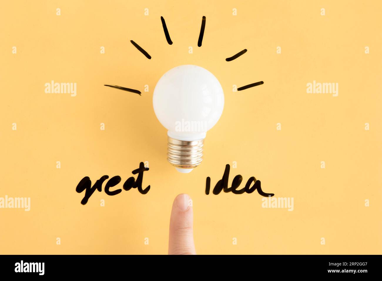 Dito umano che punta verso la lampadina con testo di grande idea Foto Stock