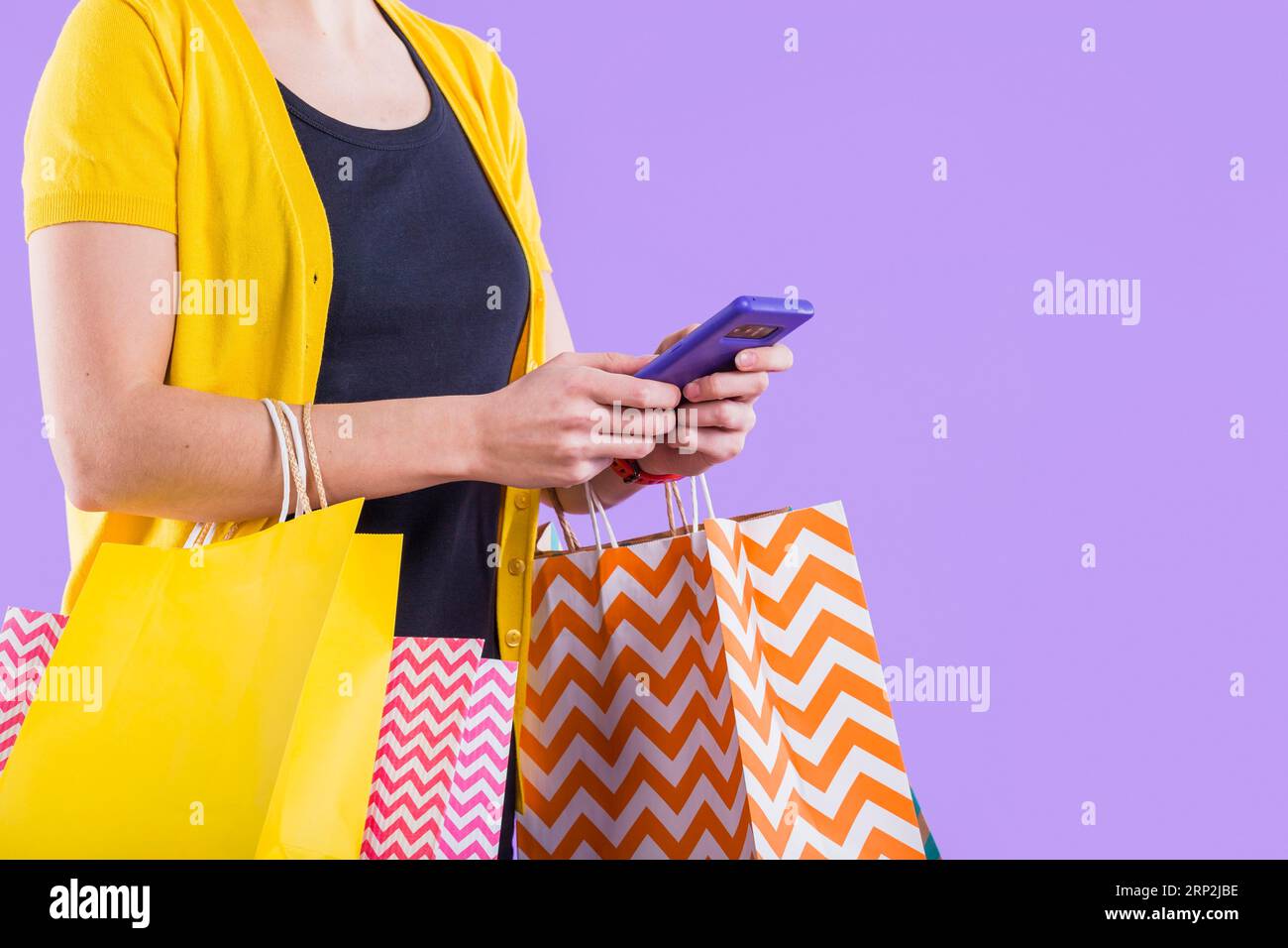 Primo piano la mano della donna utilizzando il cellulare bianco borsa per la spesa Foto Stock